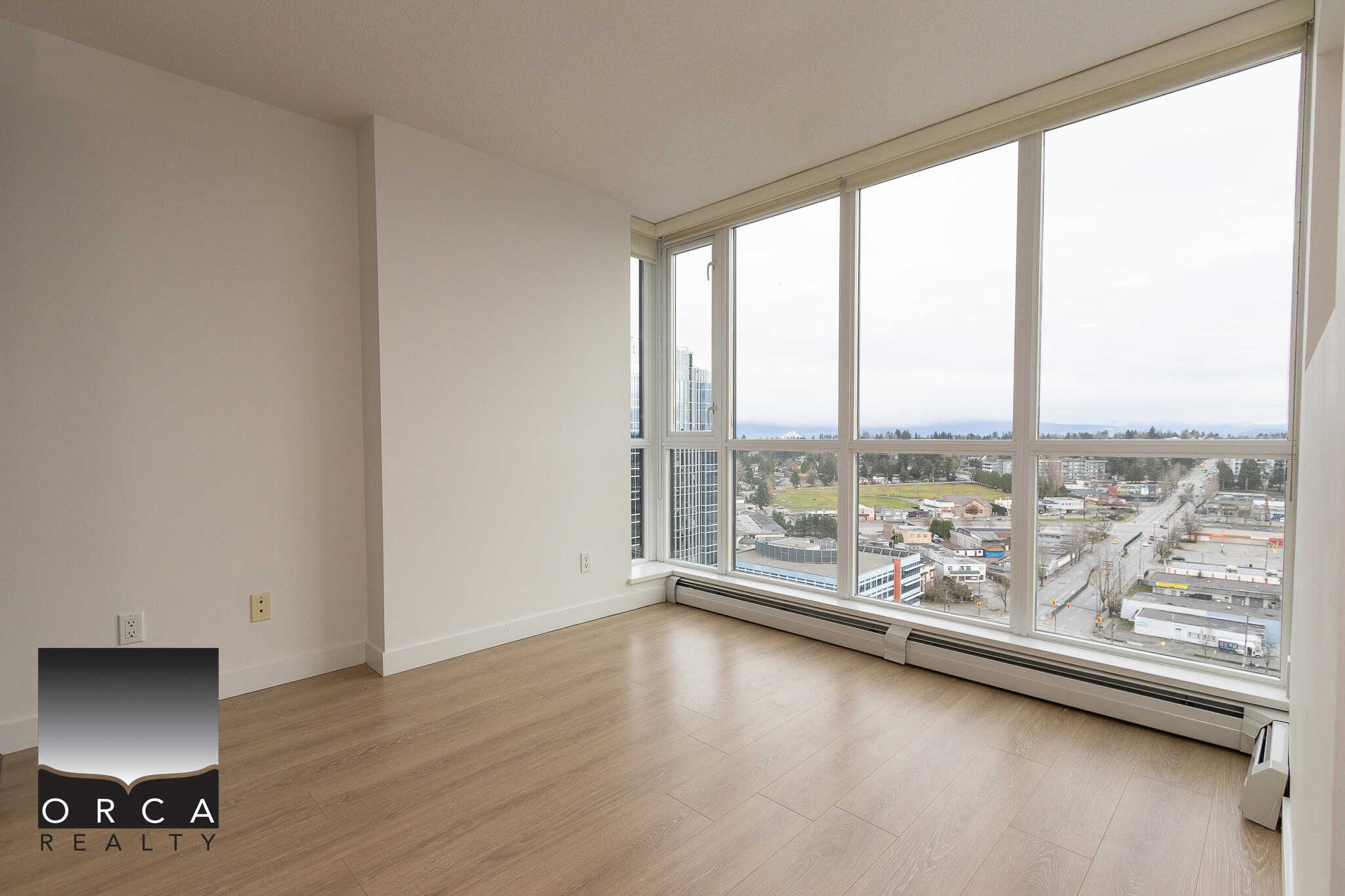 Bright, modern condo interior with large floor-to-ceiling windows offering panoramic city and river views in Vancouver, BC. Perfect for urban living and investment.