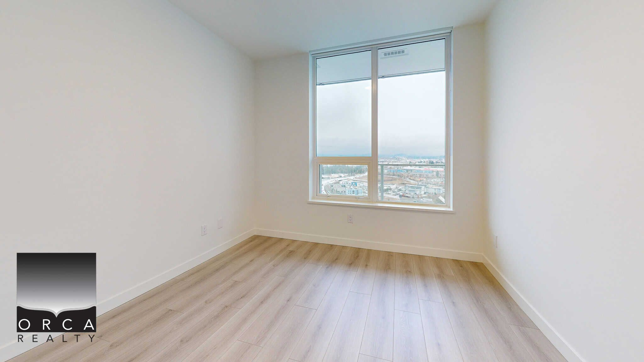 Bright modern bedroom with large window overlooking cityscape, hardwood flooring, and simple white walls, perfect for city living and real estate investment in Vancouver.