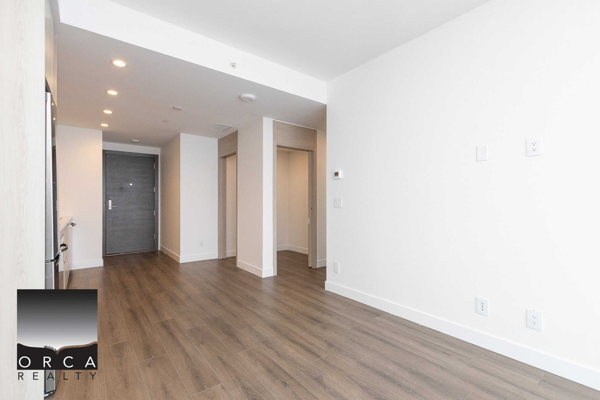 16 Modern interior apartment with white walls, wooden flooring, and contemporary design, showcasing Orca Realty Inc.'s professional property listings in Vancouver.