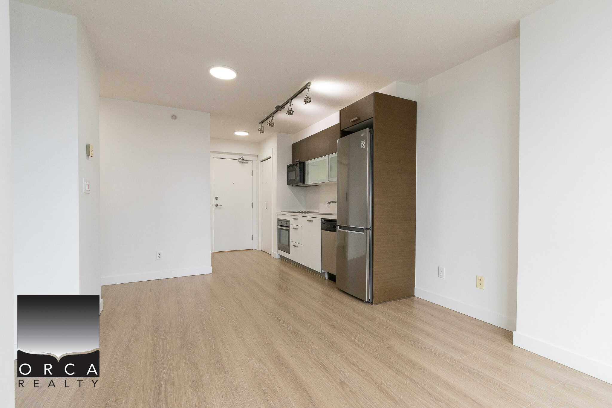 Spacious modern condo kitchen with stainless steel appliances and light wood flooring, perfect Vancouver real estate investment or primary residence.