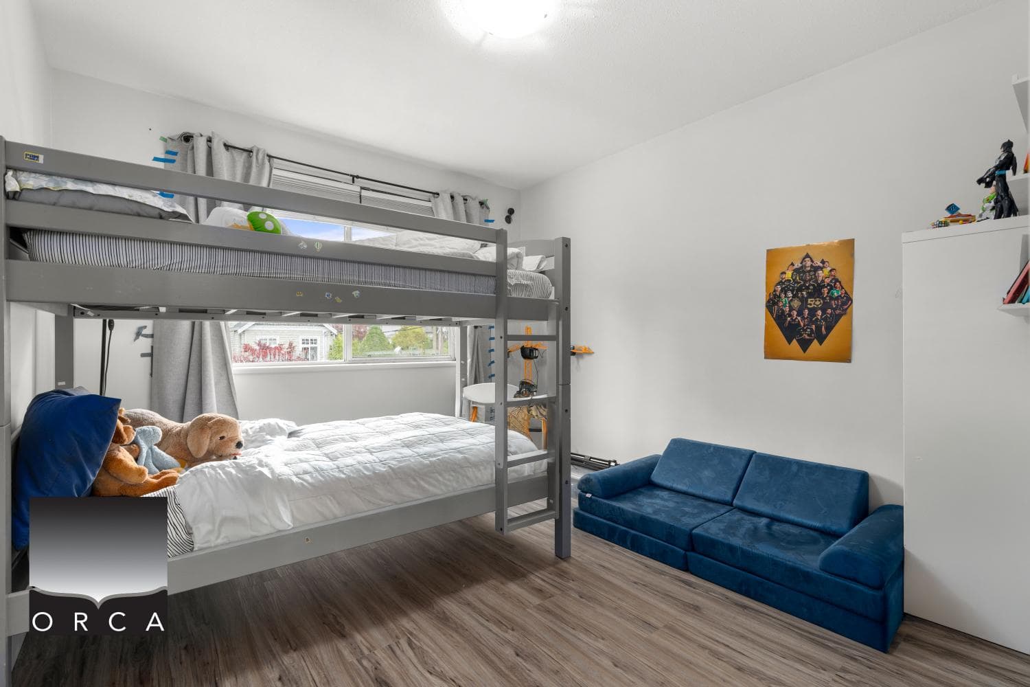 Bright children's bedroom featuring bunk beds, a blue sofa, and playful decor, ideal for families seeking homes through Orca Realty Inc. in British Columbia.