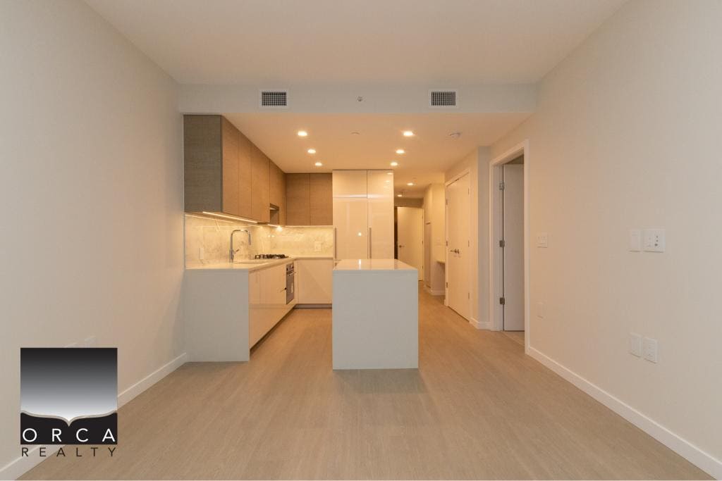 Modern open-concept kitchen with minimalist design, neutral colour palette, and sleek cabinetry, ideal for property buyers seeking contemporary homes in Vancouver.