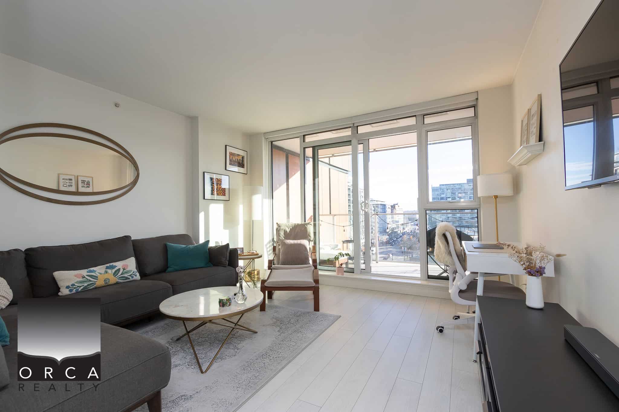 Bright and modern living room in a Vancouver condo with large windows, balcony access, contemporary furnishings, and natural light, perfect for urban living and real estate investments.