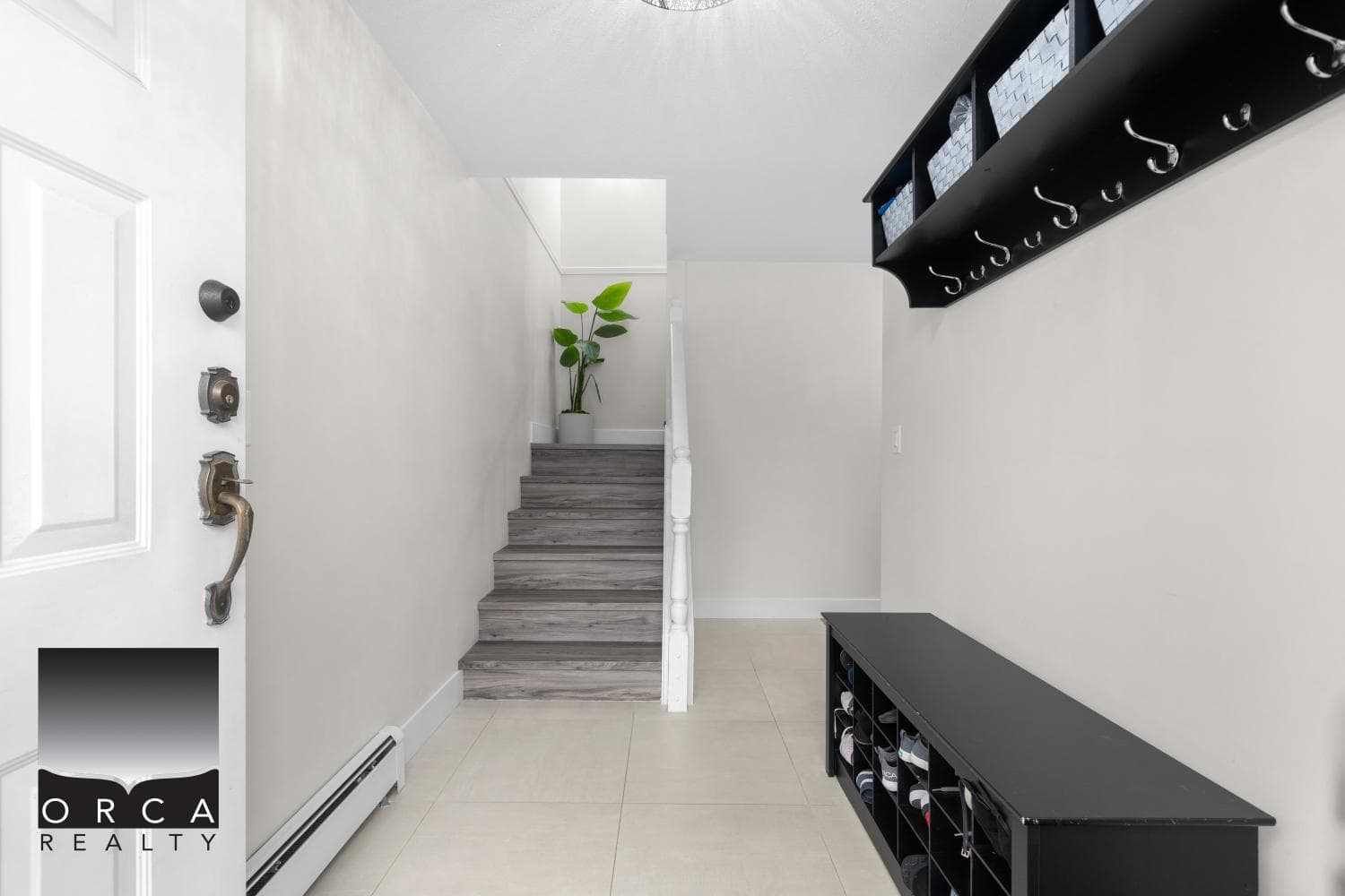 Modern home entryway with stairs, shoe storage, and minimalist decor - perfect for Vancouver area homes.