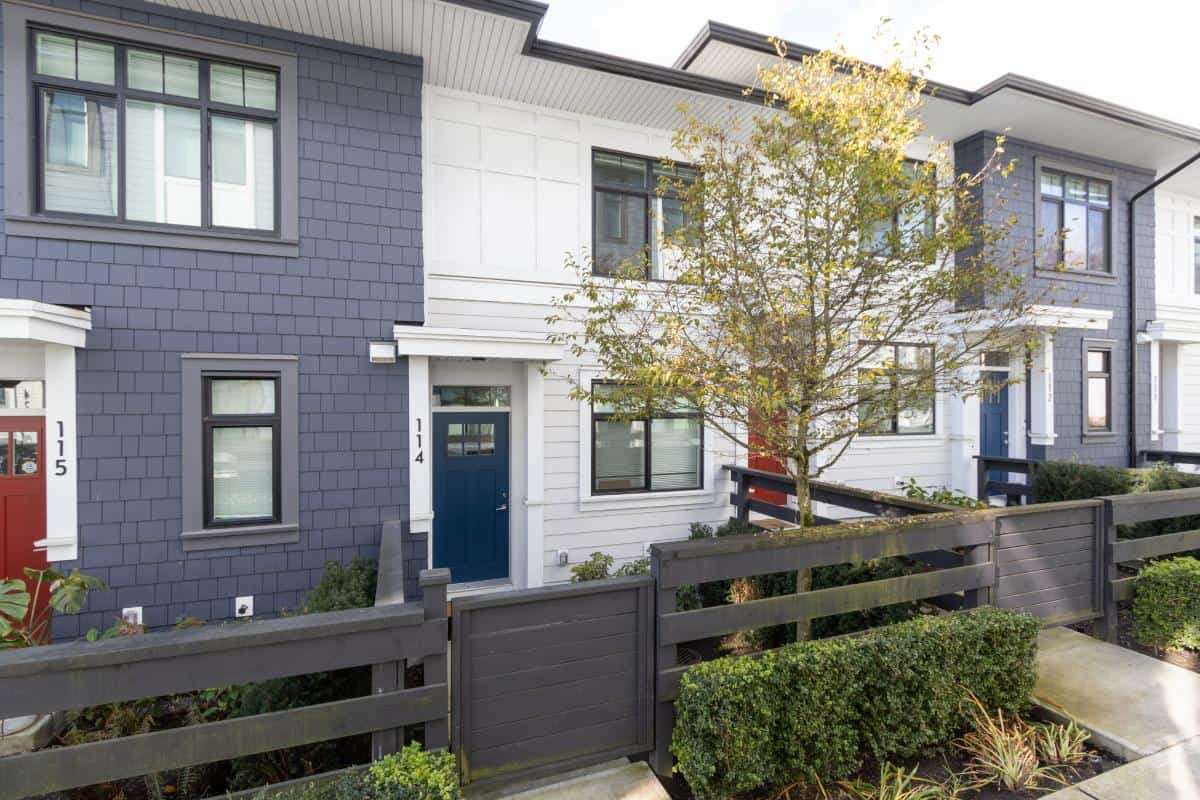 Modern multi-family townhouse with stylish exterior, large windows, and well-maintained landscaping in a desirable neighbourhood in British Columbia.
