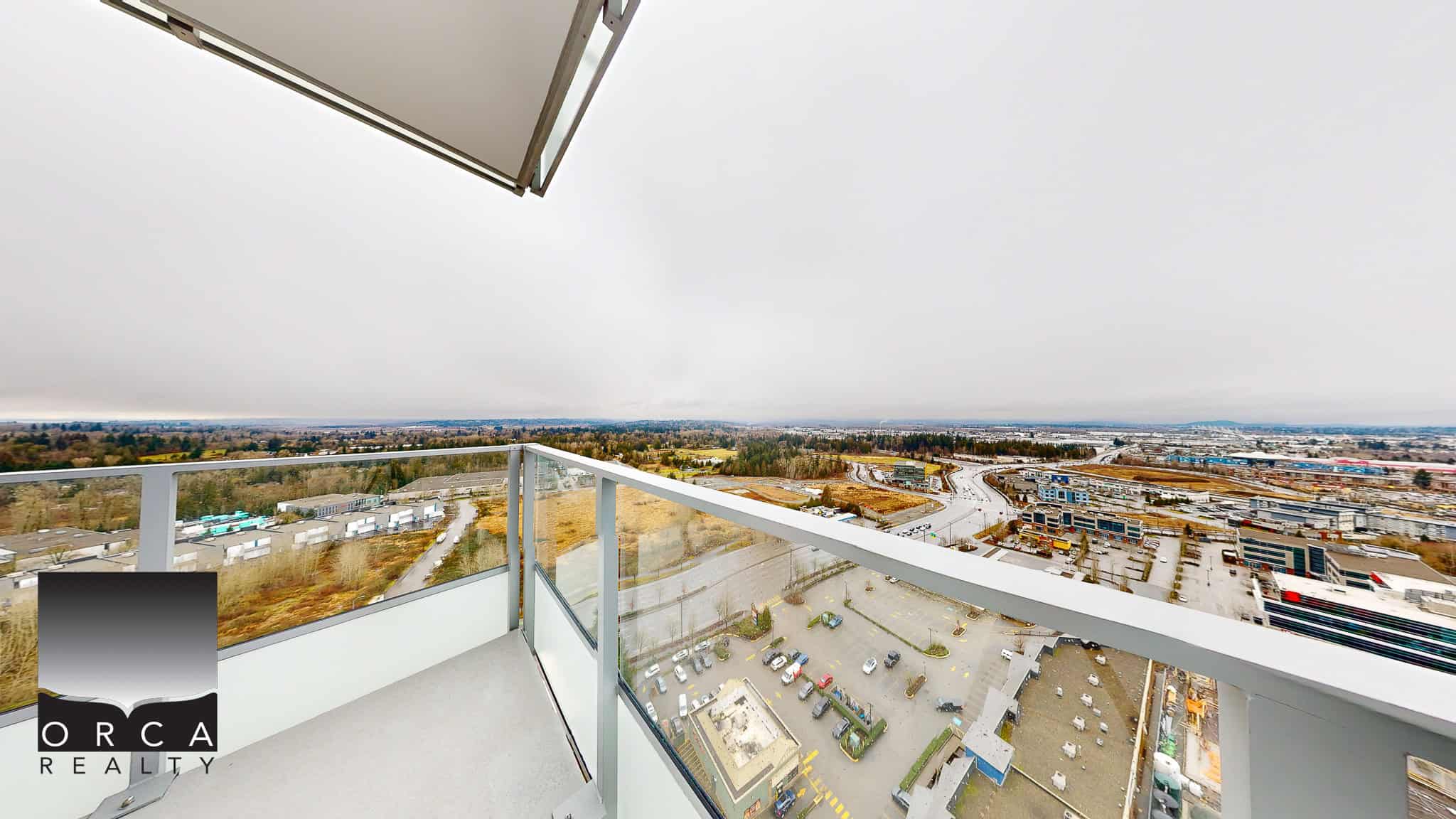 Stunning city view from a high-rise balcony overlooking commercial and industrial areas, showcasing modern urban living and real estate opportunities in Vancouver, BC.