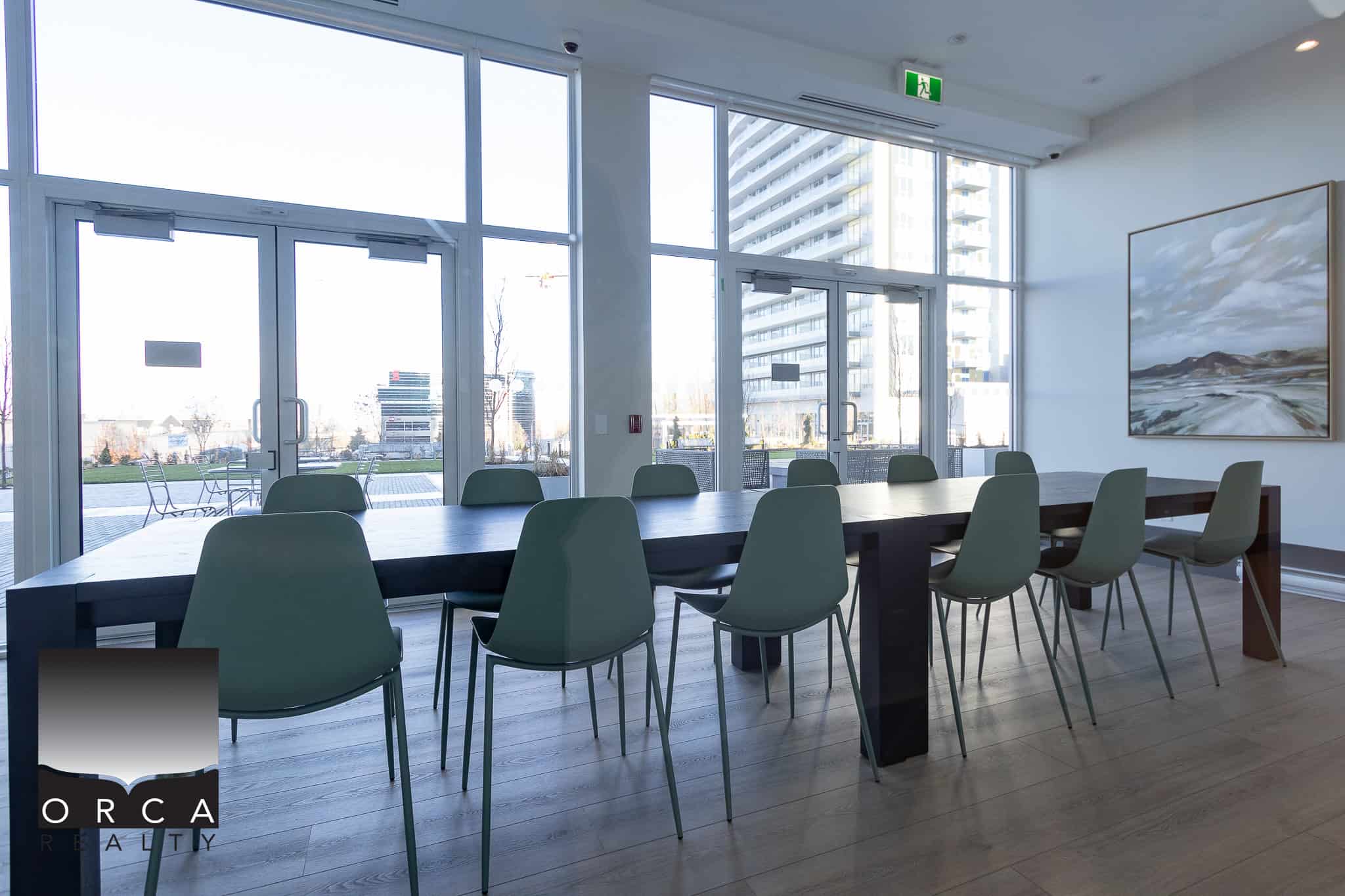 Modern commercial conference room with large windows showcasing outdoor urban views, ideal for meetings and business events at Orca Realty Inc.