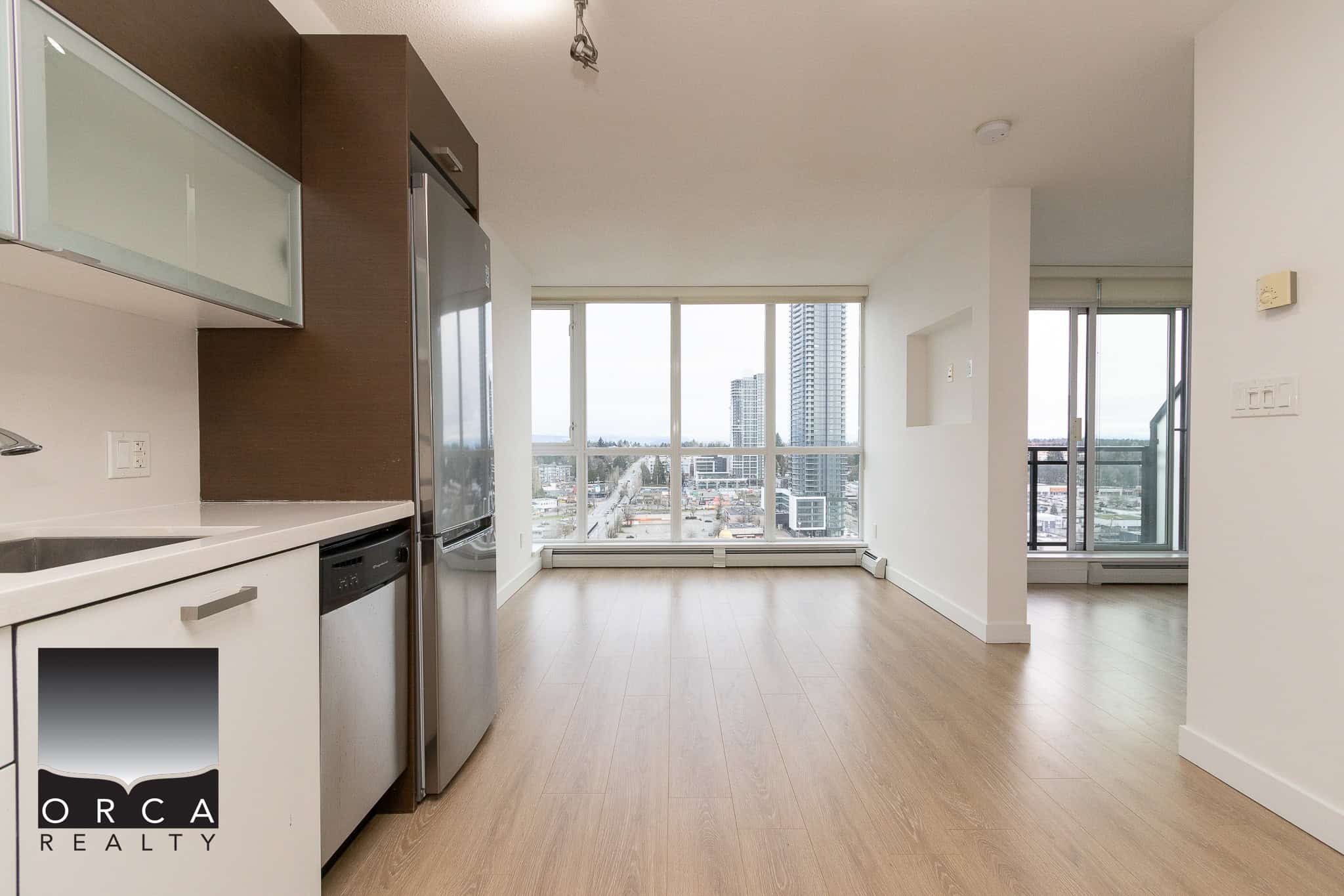 Modern Vancouver city view apartment with bright open-concept living area and floor-to-ceiling windows, featuring contemporary kitchen design, hardwood floors, and a private balcony.