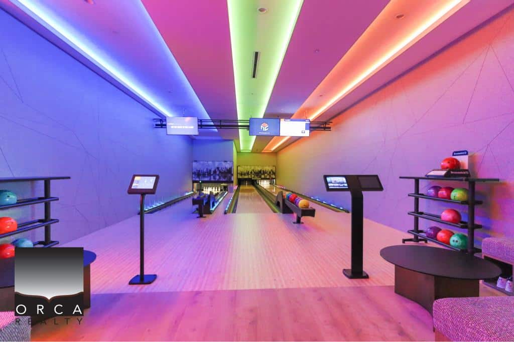 Vibrant indoor bowling alley with multicolored LED lighting and modern design at Orca Realty Inc., ideal for real estate agents to showcase luxury properties with entertainment amenities.