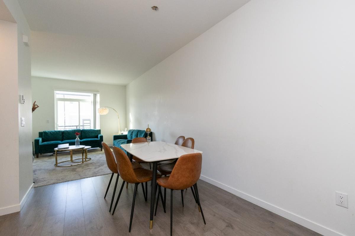 Modern open-concept living and dining room in a Vancouver condo with stylish furnishings, natural light, and contemporary decor, perfect for first-time homebuyers and investors.