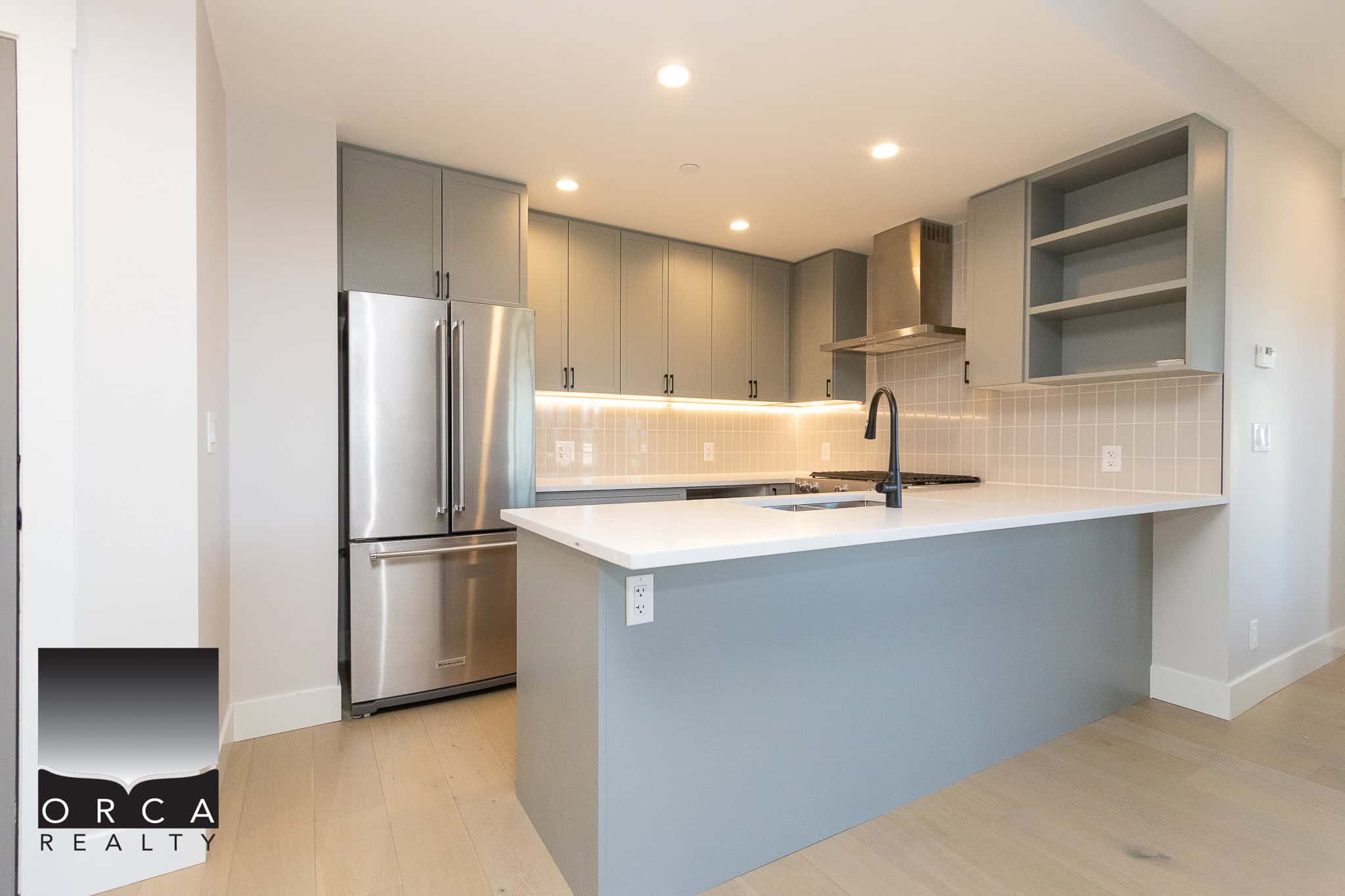 Modern grey and white kitchen with stainless steel appliances and minimalist design, perfect for Vancouver real estate buyers interested in contemporary homes.