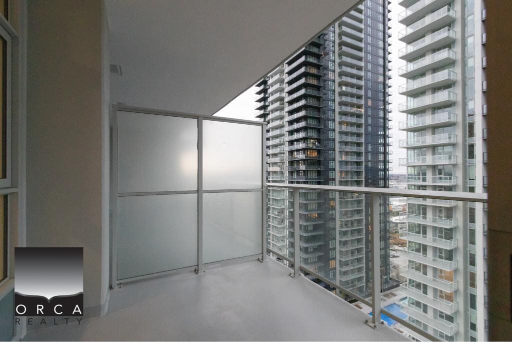 Modern balcony in high-rise condominium with city views, perfect for relaxing or entertaining, offered by Orca Realty Inc. in Vancouver, BC.