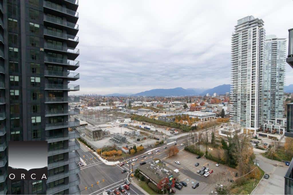 Modern high-rise condominium buildings in downtown Vancouver with panoramic city and mountain views, showcasing Orca Realty Inc.'s expertise in Vancouver real estate.