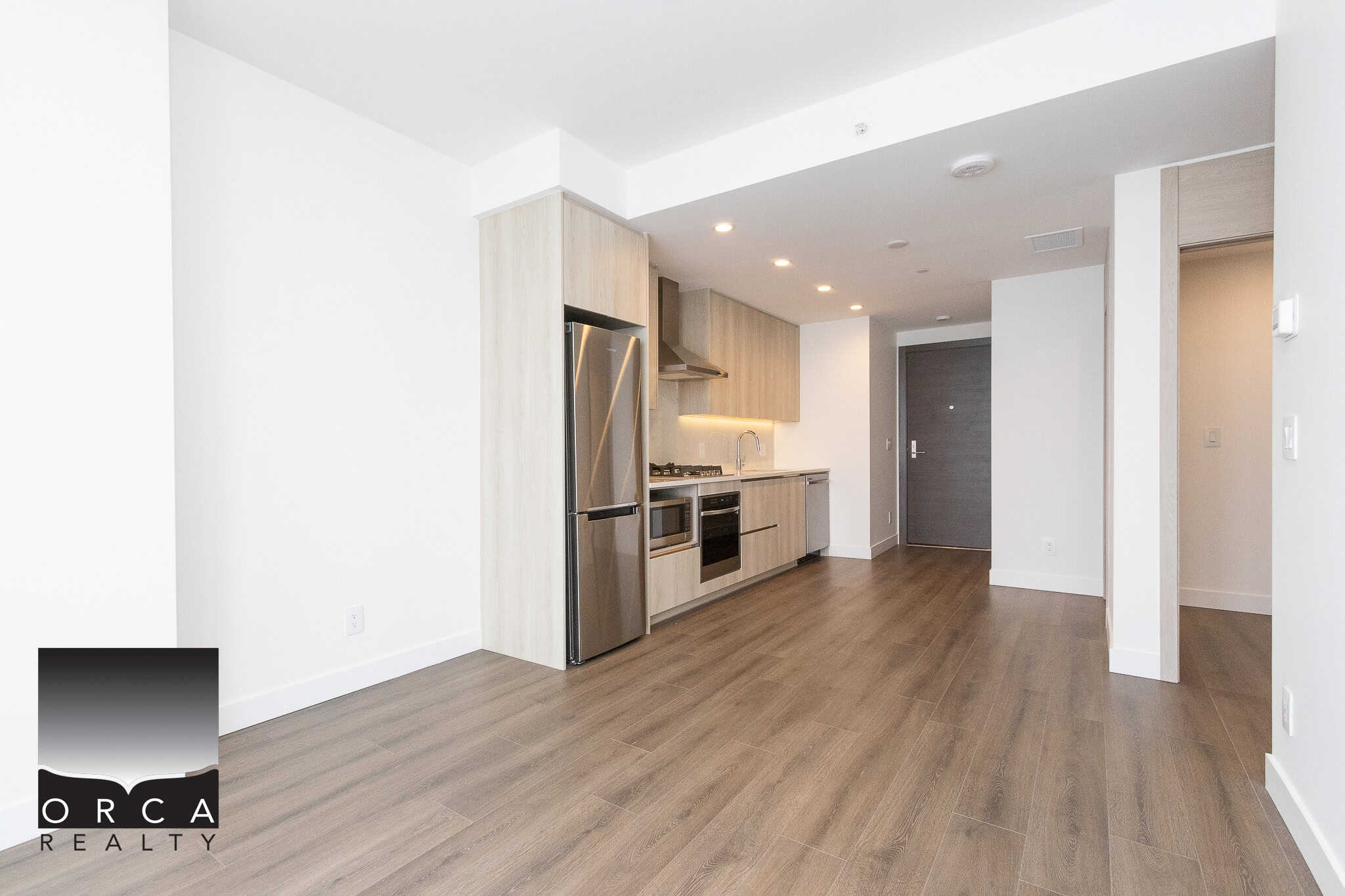 7 Contemporary kitchen in modern condo with stainless steel appliances, light wood cabinetry, and open floor plan, perfect for Vancouver real estate buyers seeking stylish, functional homes.