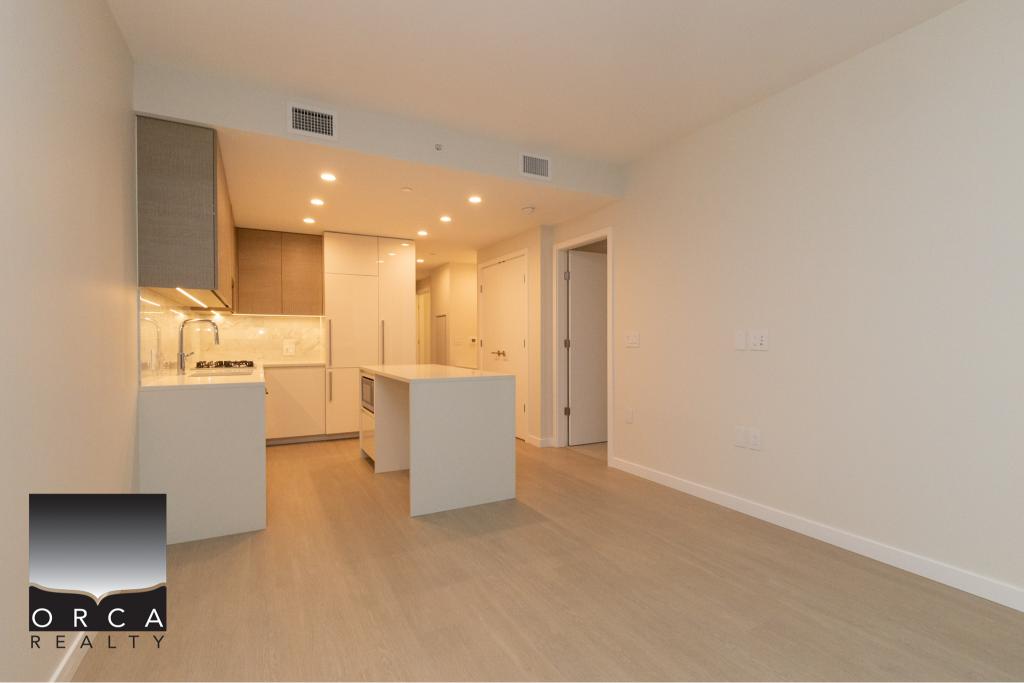 Contemporary kitchen with modern appliances and sleek cabinetry in a stylish condo or apartment. Perfect for urban living, featuring open space and high-end finishes.