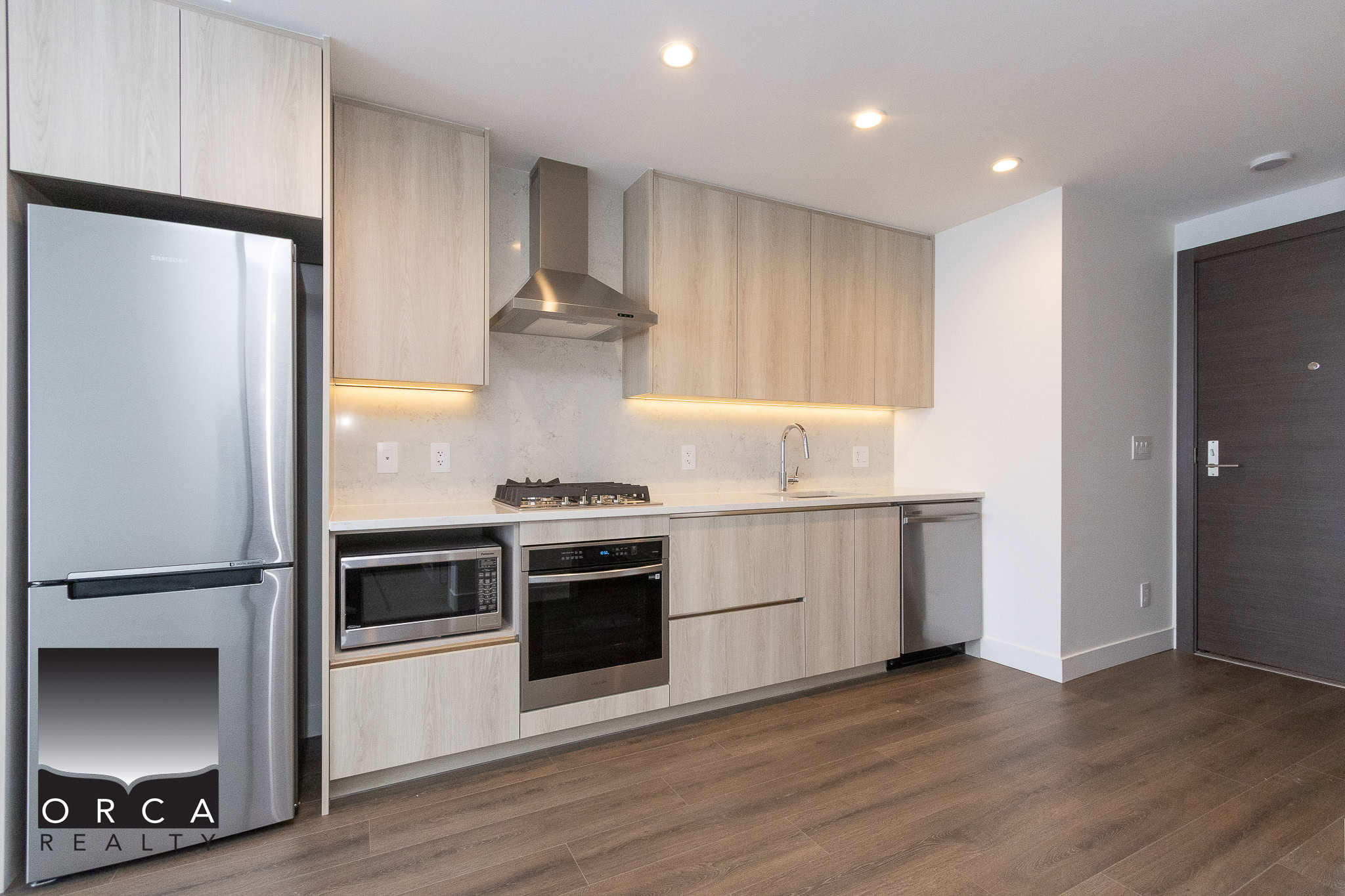 8 Modern kitchen with stainless steel appliances and light wood cabinetry, featuring a gas stove, oven, microwave, and dishwasher, ideal for Vancouver real estate listings.