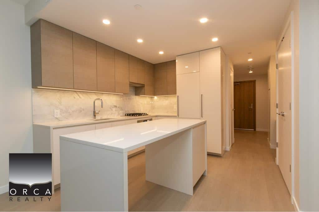 Modern open-concept kitchen with minimalist cabinetry and sleek countertops in a Vancouver property listed by Orca Realty Inc.