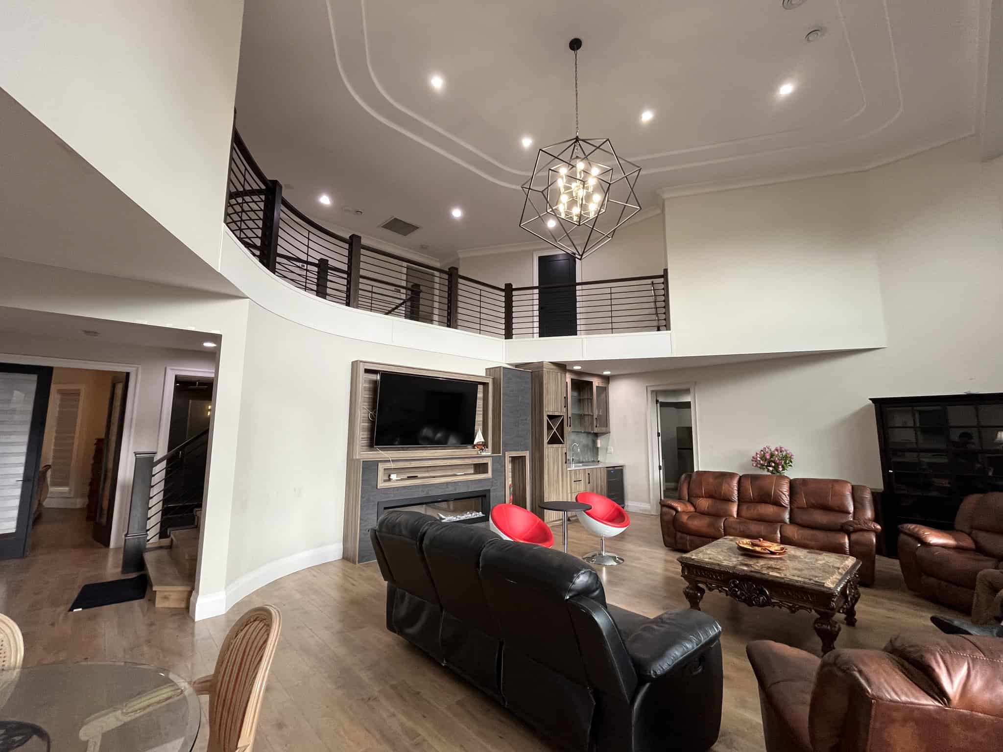 Spacious modern living room with high ceilings, contemporary lighting, and stylish furniture, showcasing luxury home interior design by Orca Realty Inc. in the Vancouver area.