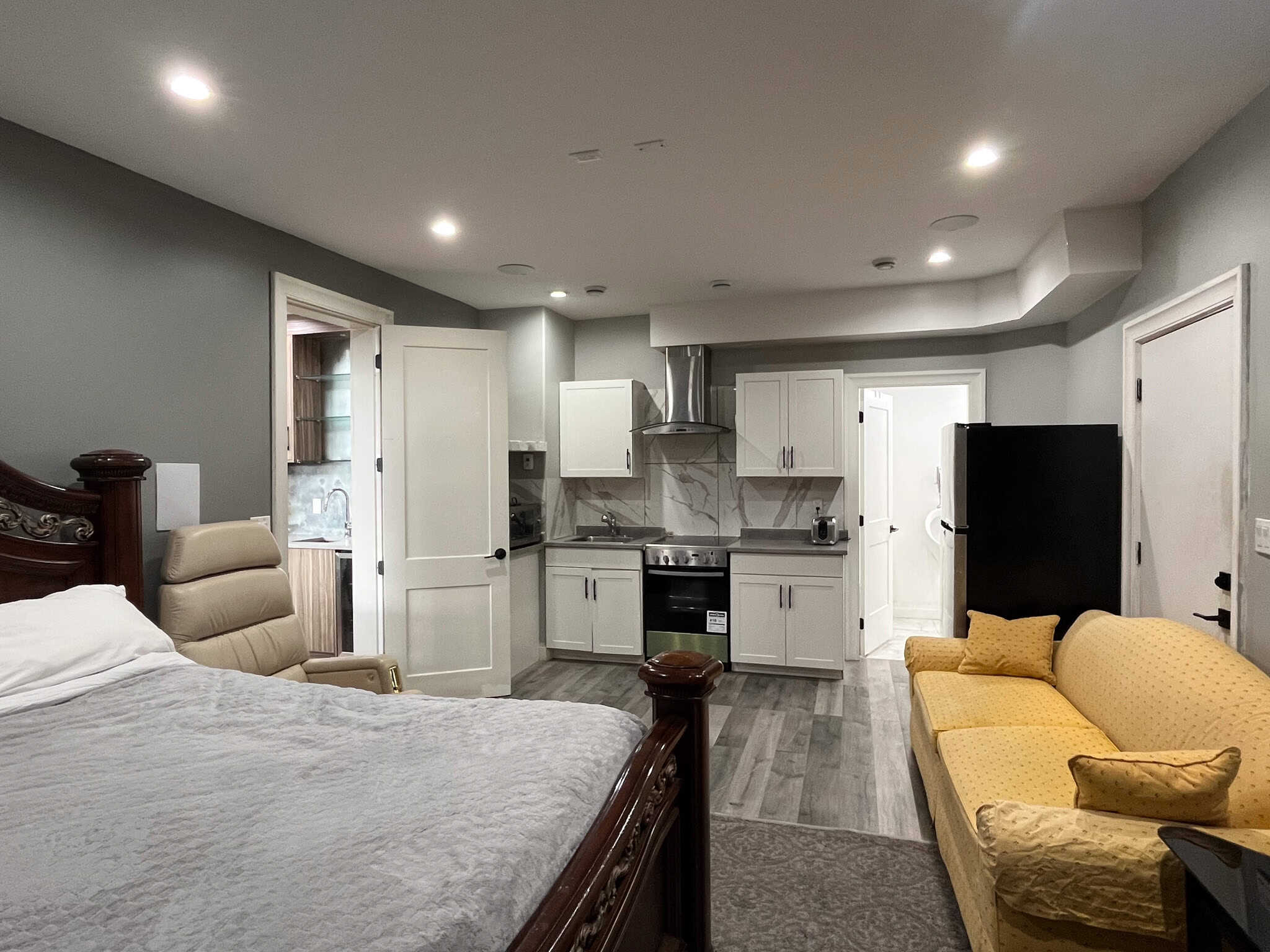 Modern studio apartment interior with kitchenette, sleeping area, and cosy seating, showcasing Vancouver Island property rentals by Orca Realty Inc. in BC, Canada.