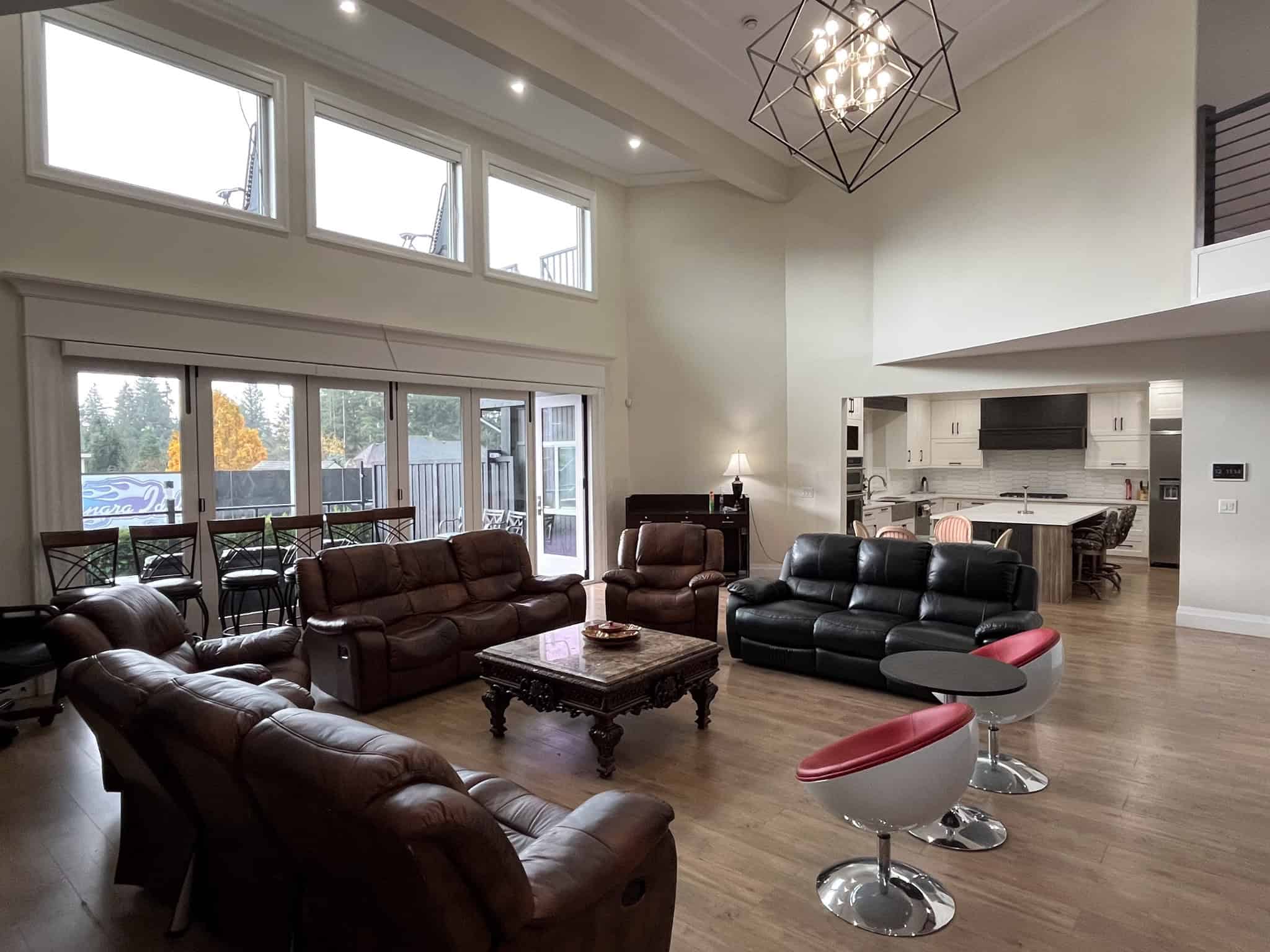 Spacious modern living room with high ceilings and large windows, open-concept design, stylish seating, and contemporary decor ideal for family gatherings and entertaining guests.