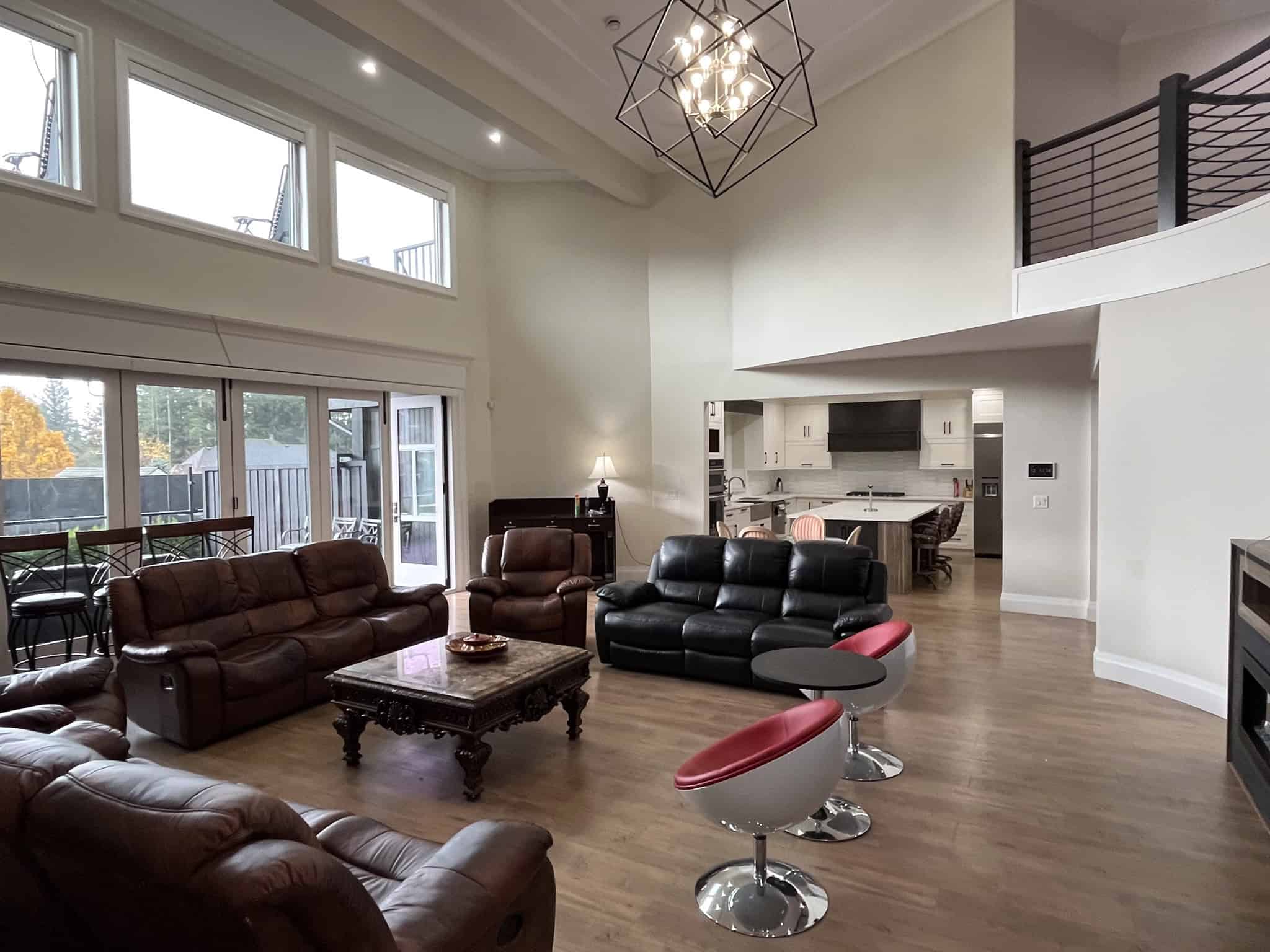 Modern open-concept living room with high ceilings, large windows, and contemporary furnishings, showcasing luxury real estate by Orca Realty Inc. in Vancouver, BC.