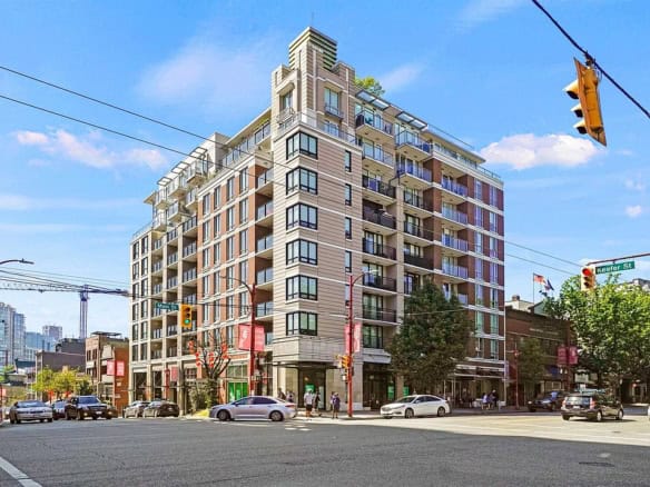 Contemporary downtown mixed-use residential building in Vancouver, British Columbia. Modern apartments and commercial spaces with street-level retail in a vibrant urban setting.