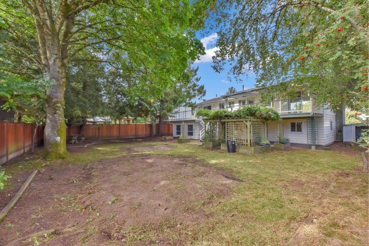 Lush backyard with mature trees, spacious lawn, and a multi-level deck in a family-friendly neighbourhood. Perfect for outdoor entertaining, gardening, and creating your dream outdoor space.