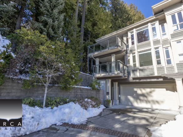 Spacious modern townhouse with multiple outdoor balconies, situated next to lush greenery and trees, available through Orca Realty Inc., ideal for buyers seeking a serene and contemporary residential property in BC.