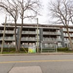 Modern multi-family residential apartment building with glass balconies located in a Vancouver neighbourhood, perfect for real estate investment opportunities and rental income in BC.