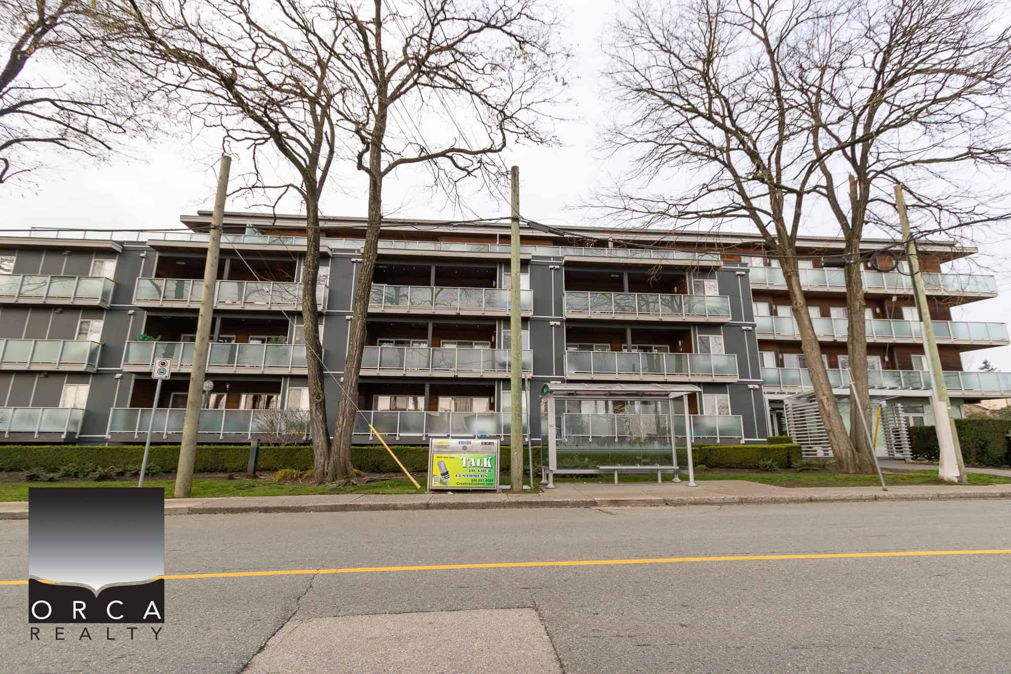 Modern multi-family residential apartment building with glass balconies located in a Vancouver neighbourhood, perfect for real estate investment opportunities and rental income in BC.