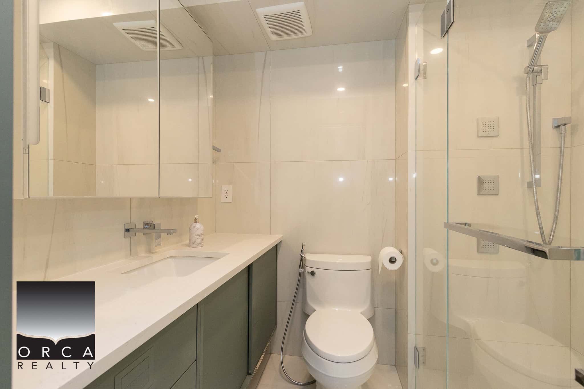 Modern renovated bathroom with glass shower enclosure, sleek vanity, and contemporary fixtures, ideal for Vancouver and Greater Vancouver real estate market.