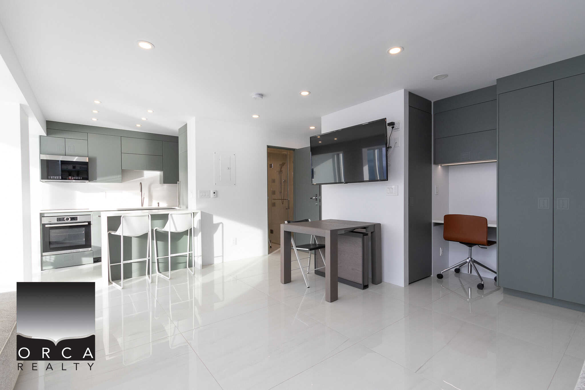 Spacious modern kitchen and living area with sleek cabinetry, integrated appliances, and comfortable workspace, ideal for Vancouver Island real estate homes.
