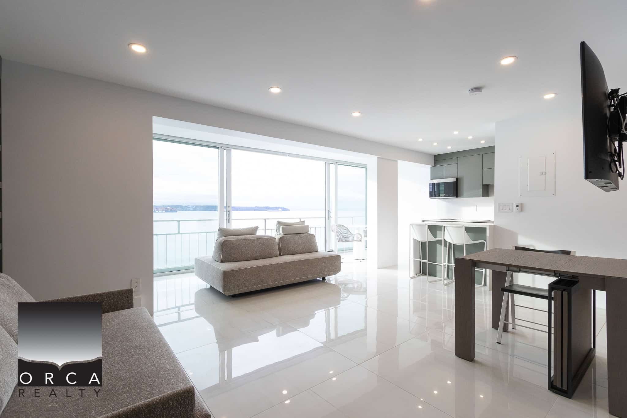 Modern waterfront living room with bright natural light, contemporary furniture, and ocean views in Vancouver, BC. Perfect for luxury real estate and beachfront property showcases.