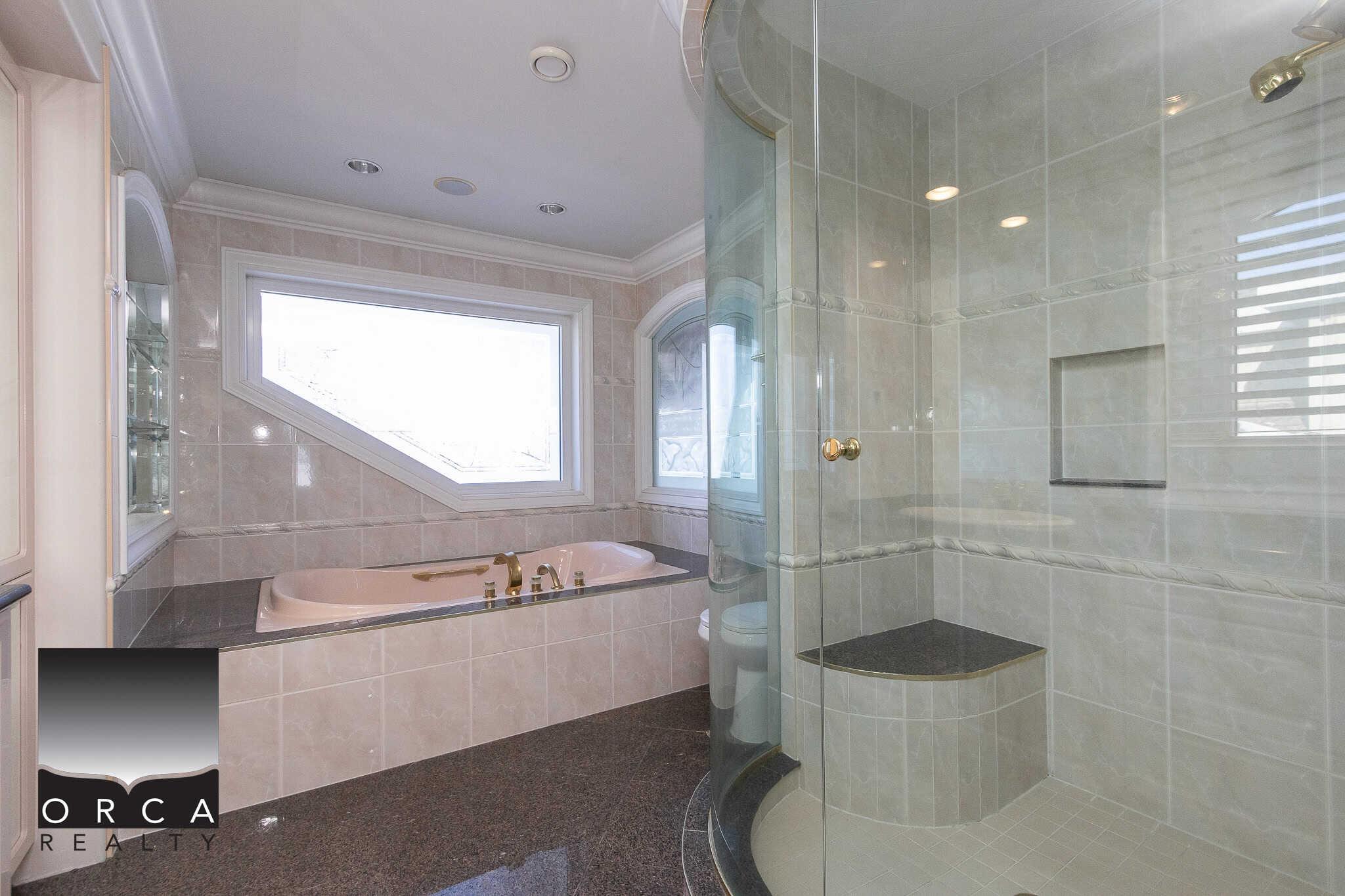 16 Luxurious bathroom with tub and glass-enclosed shower, featuring modern fixtures and elegant tile work, perfect for relaxing and unwinding in a upscale home or property.