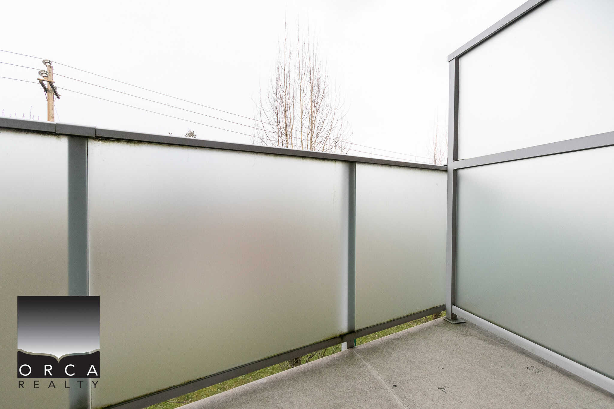 Modern frosted glass balcony railing in a contemporary residential exterior, featuring sleek metal framing, ideal for privacy and style in Vancouver homes.