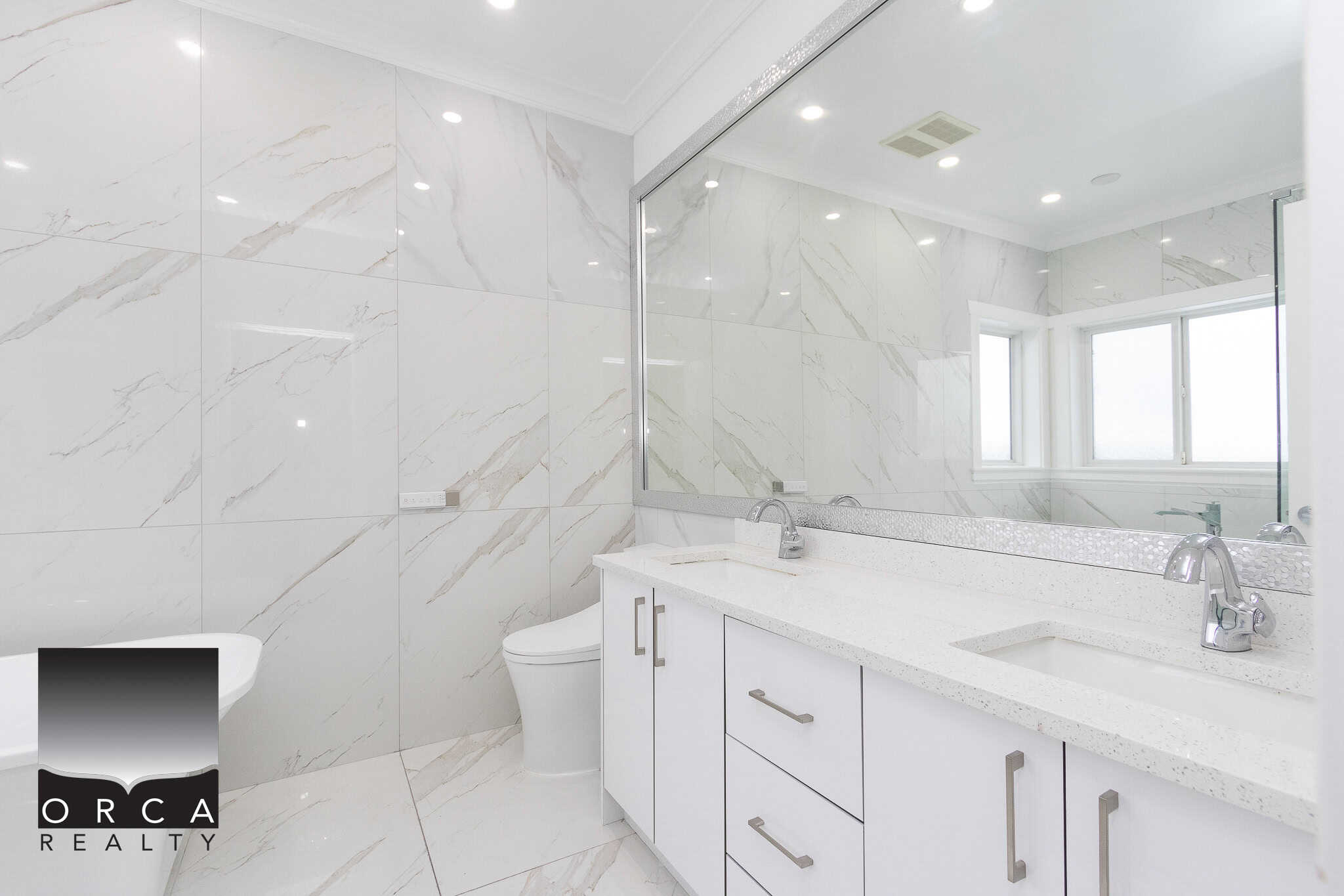 19 Modern luxury bathroom with white marble tiles, dual sinks, large mirror, and contemporary fixtures, showcasing high-end residential real estate by Orca Realty Inc.