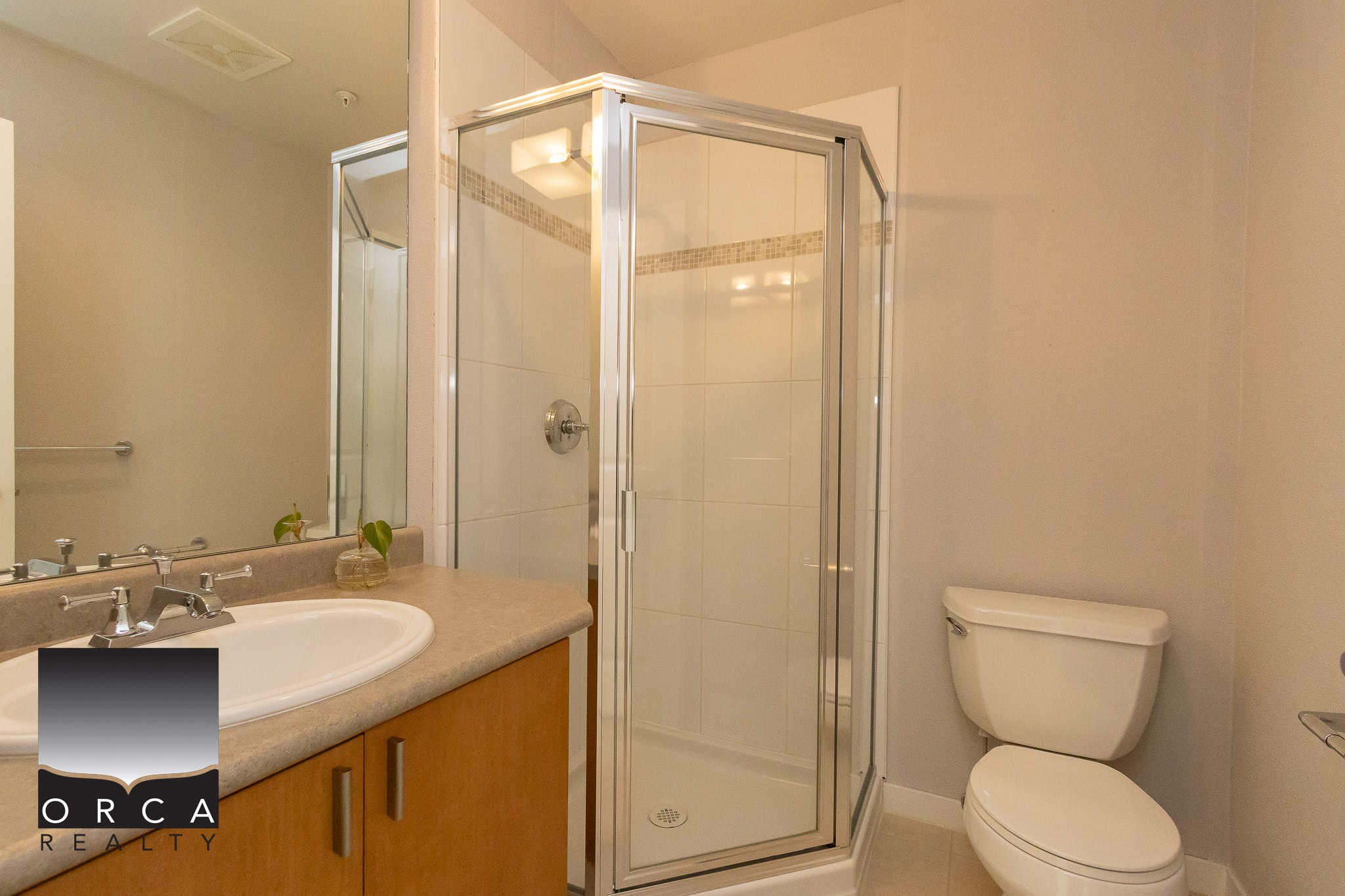 Modern bathroom with glass shower enclosure, ceramic tiles, and neutral colour palette, ideal for homebuyers seeking contemporary real estate in Ontario.
