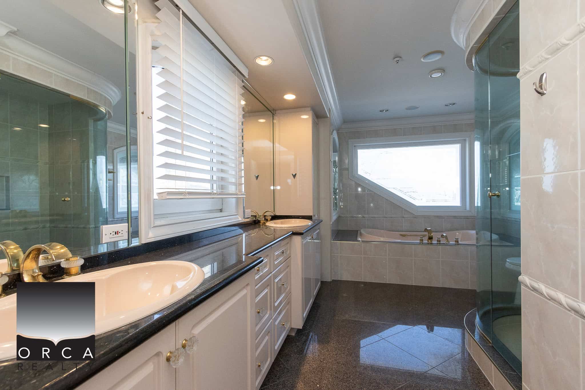 23 Spacious luxury bathroom with double sinks, a large soaking tub, and a glass-enclosed shower, featuring elegant fixtures and natural light, ideal for upscale Victoria, BC real estate.