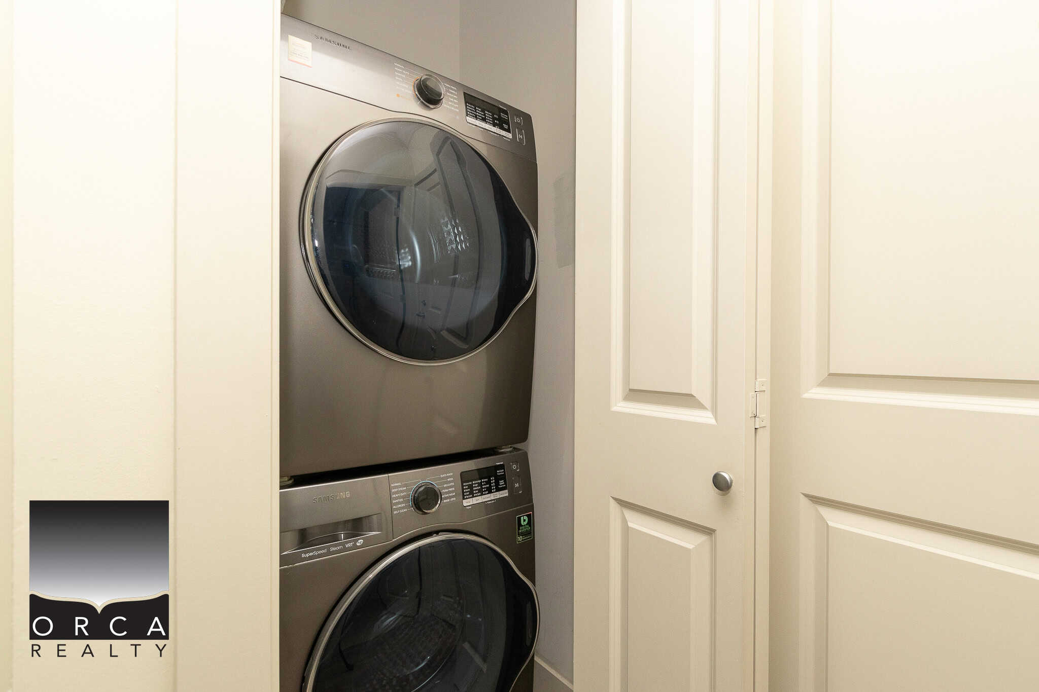 High-efficiency stacked front-load washer and dryer in a spacious laundry closet, perfect for modern homes or condos in Vancouver.