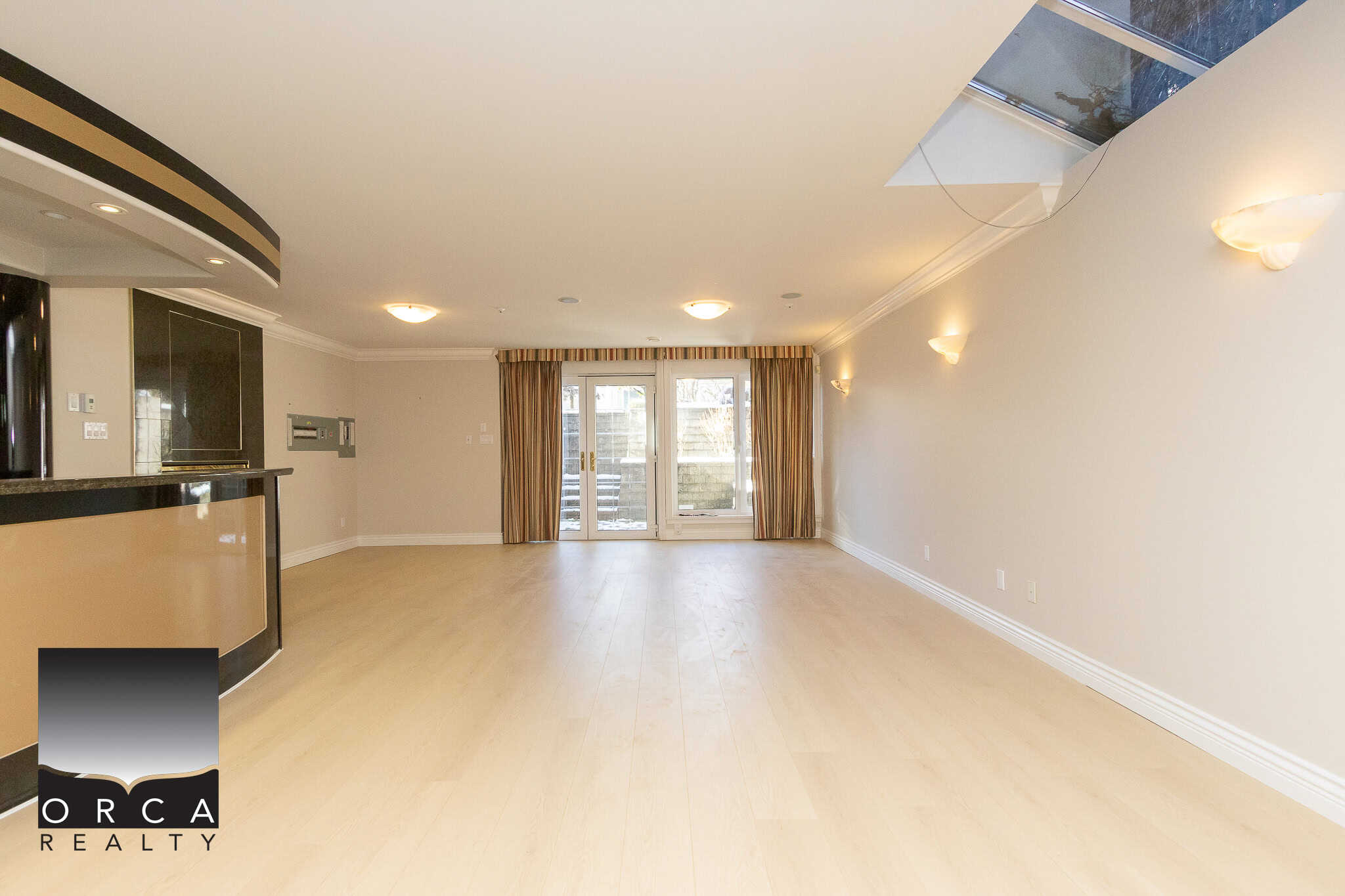 24 Bright open living space with hardwood floors, large windows, and sliding glass doors leading to a balcony, perfect for Vancouver real estate buyers seeking modern condo amenities.