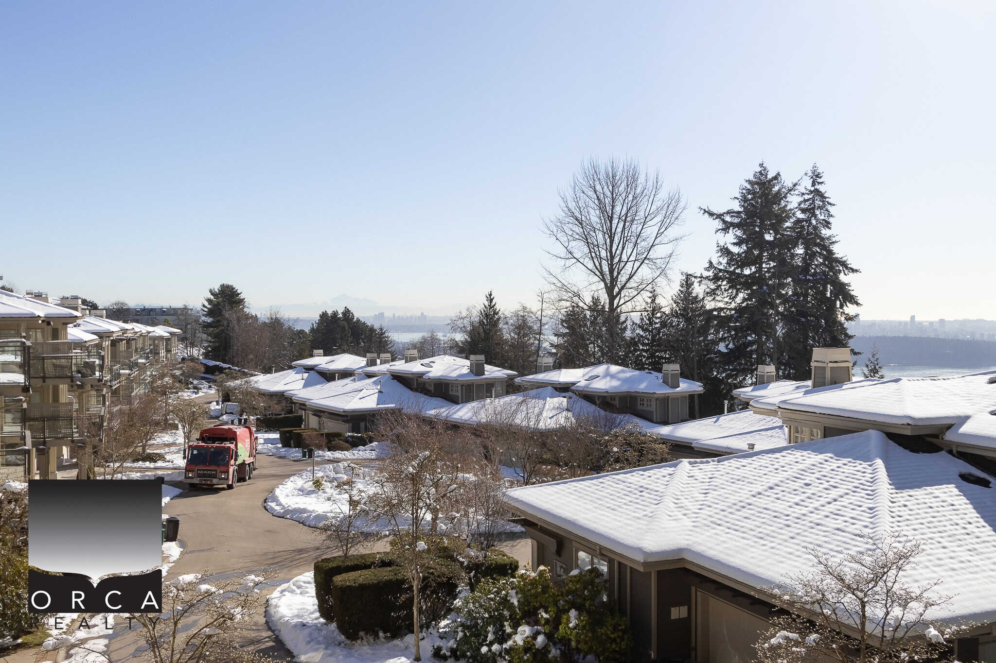 Snow-covered residential neighborhood in a Vancouver suburb during winter with modern houses and tall trees, showcasing the scenic views and community spirit, ideal for real estate listings.