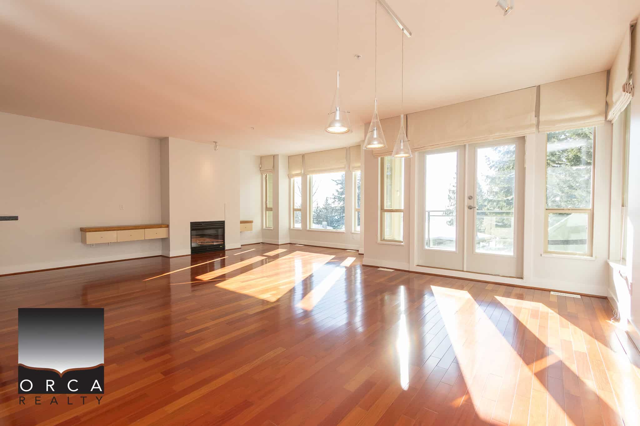 Bright spacious living room with large windows, hardwood floors, and modern fireplace, ideal for Vancouver-area real estate listings and showcasing luxury home features.