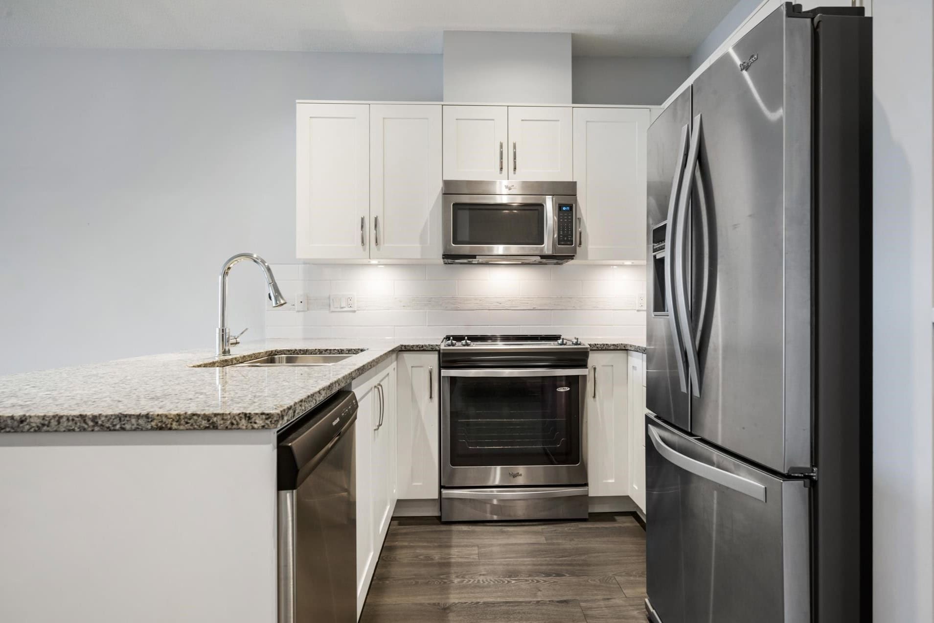Modern stainless steel kitchen appliances in a contemporary white cabinetry setup, ideal for Vancouver Island residential properties.