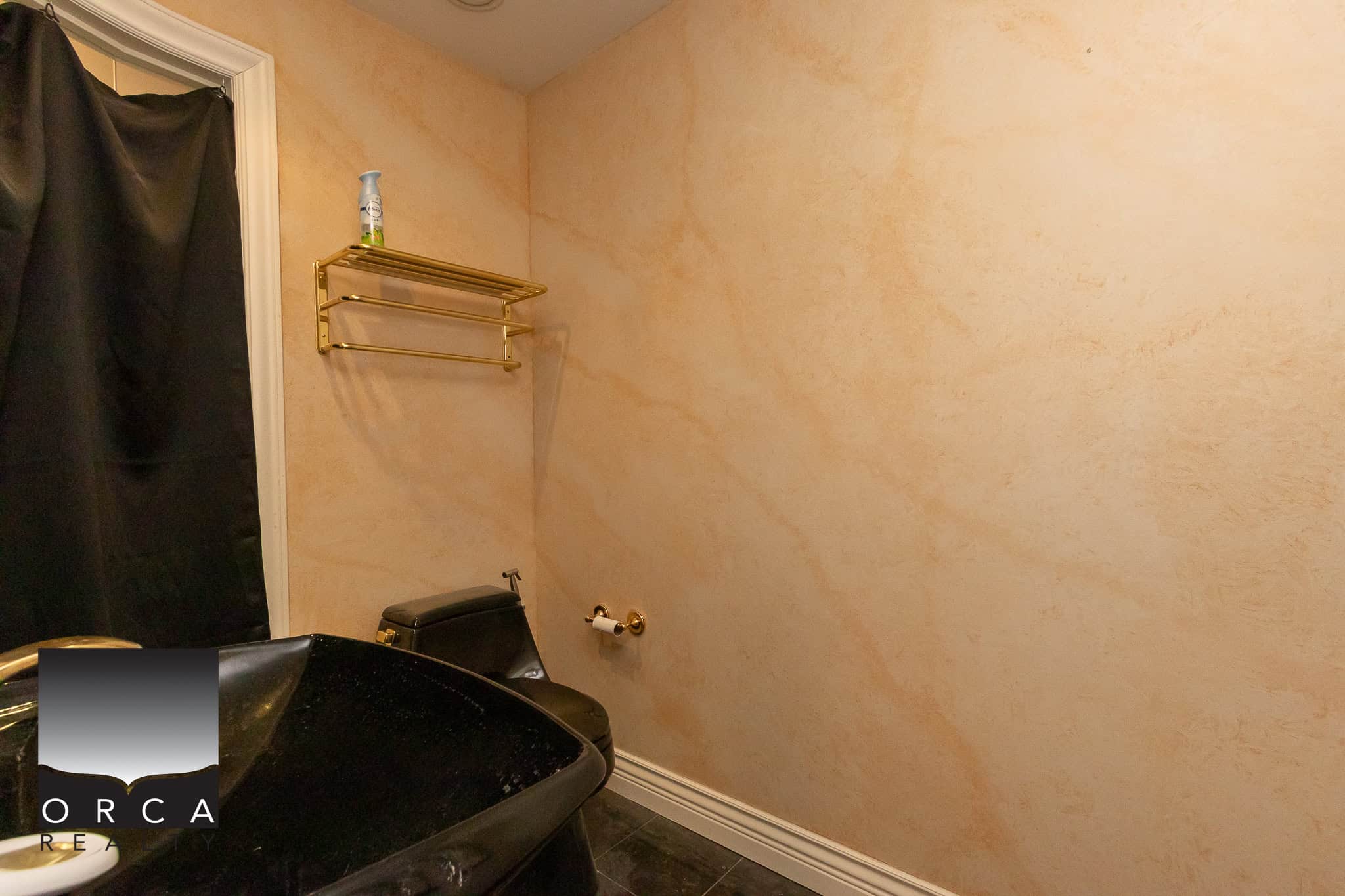 31 Clean and functional laundry room or utility space with beige textured walls, black flooring, and essential fixtures, perfect for residential or commercial properties listed through Orca Realty Inc.