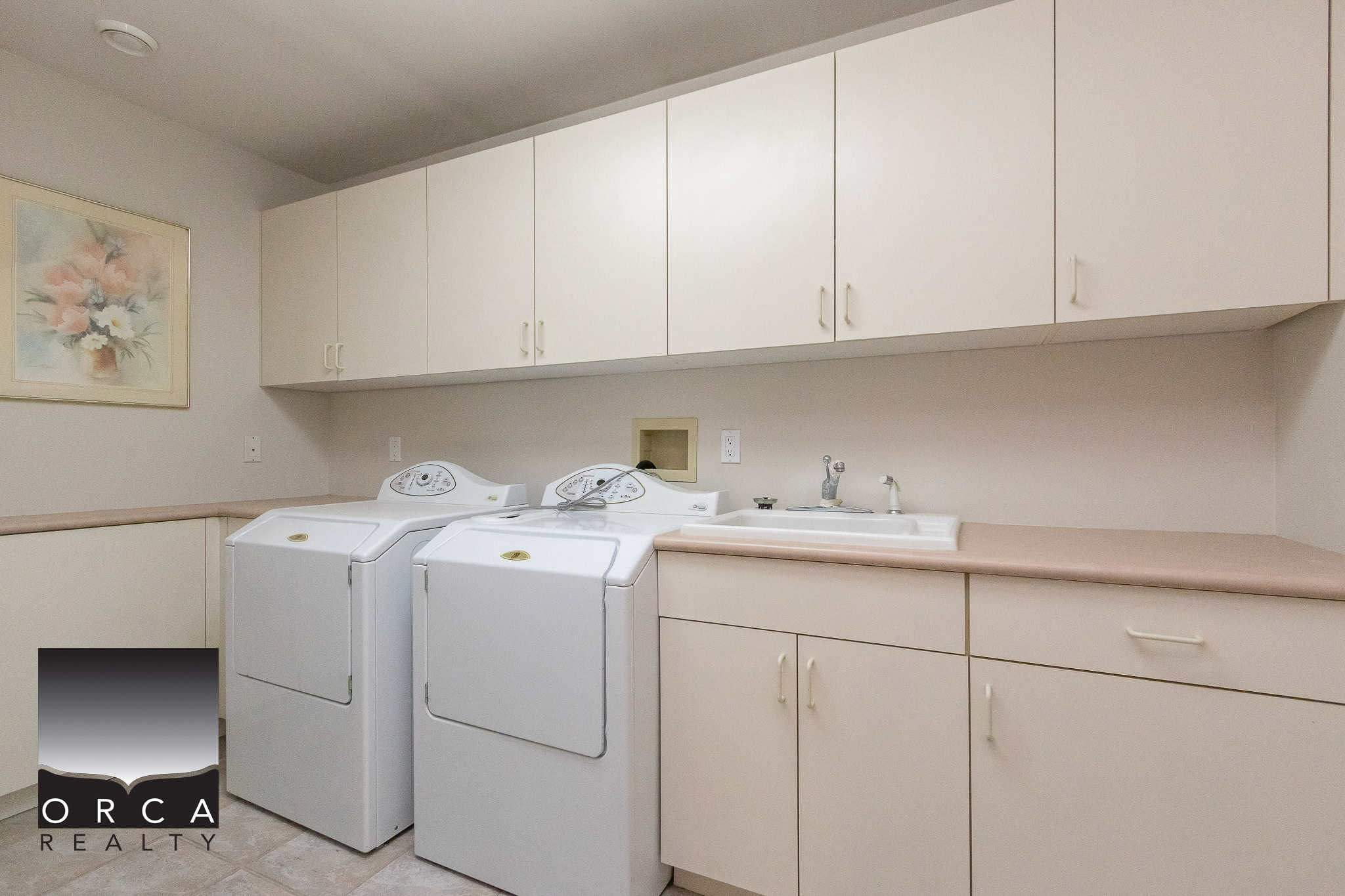 34 White laundry room with washer, dryer, and cabinetry for lease or sale in Victoria, BC, featuring modern appliances and ample storage from Orca Realty Inc.