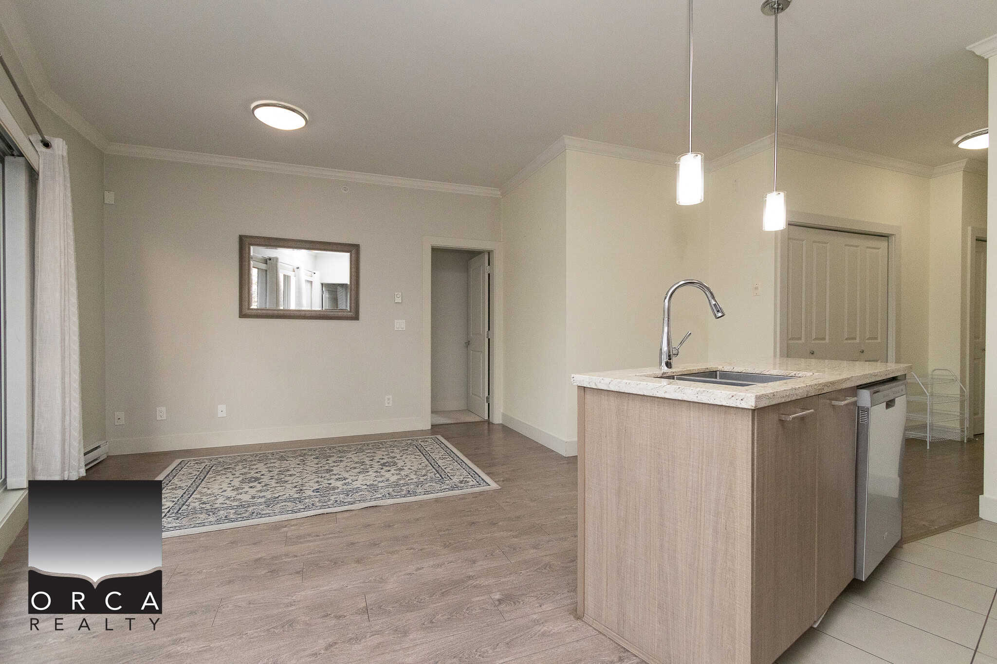 Modern open-concept kitchen and living space in a Vancouver area home, featuring granite countertops, stainless steel appliances, and hardwood flooring, perfect for family living and entertaining.