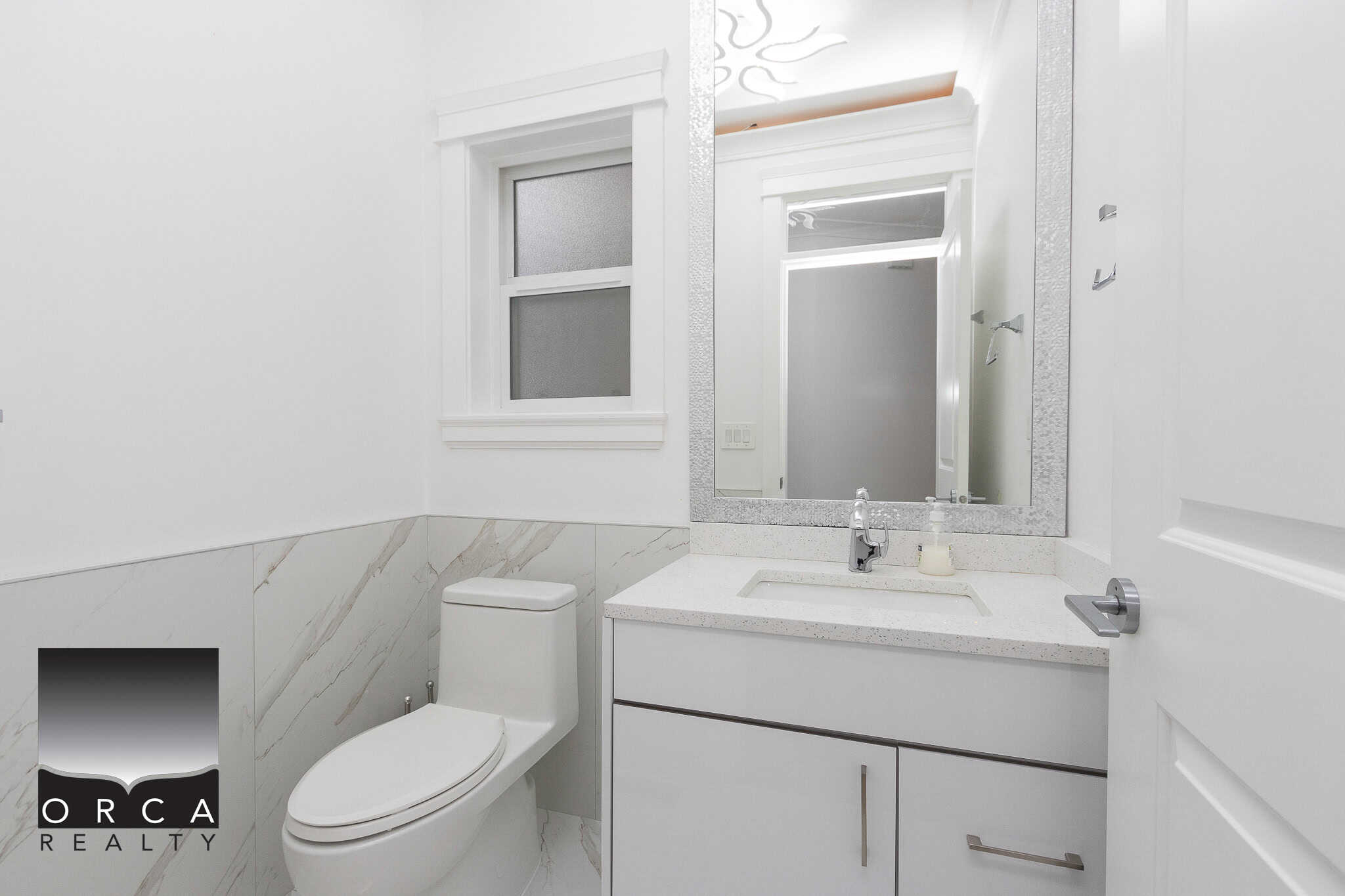 4 Bright modern bathroom with white cabinetry and marble accents, featuring a sleek toilet, large mirror, and contemporary fixtures, ideal for Vancouver island real estate listings.