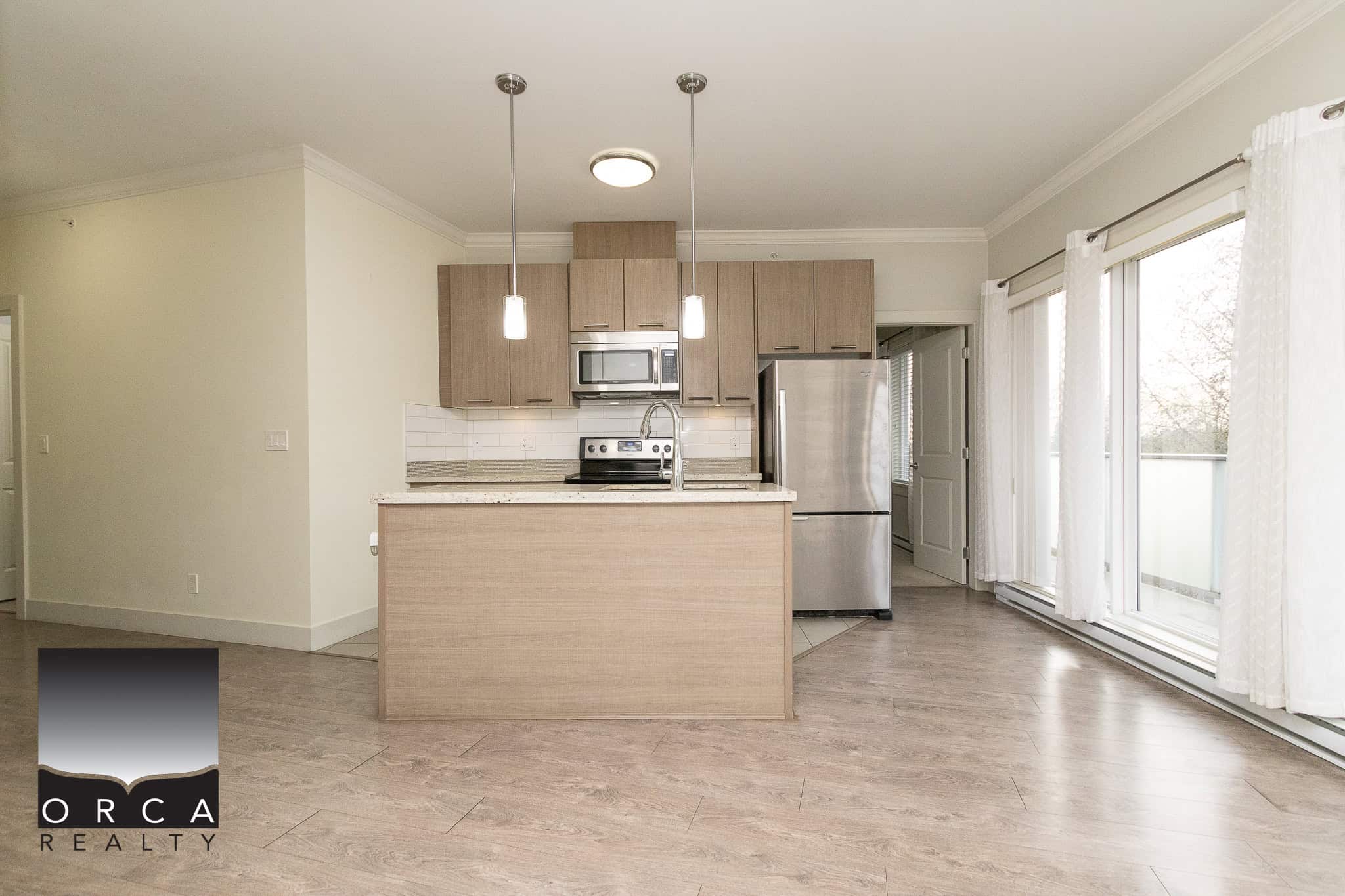 Bright modern kitchen with stainless steel appliances and natural light in a downtown Vancouver condo for sale. Open layout perfect for entertaining and comfortable living.