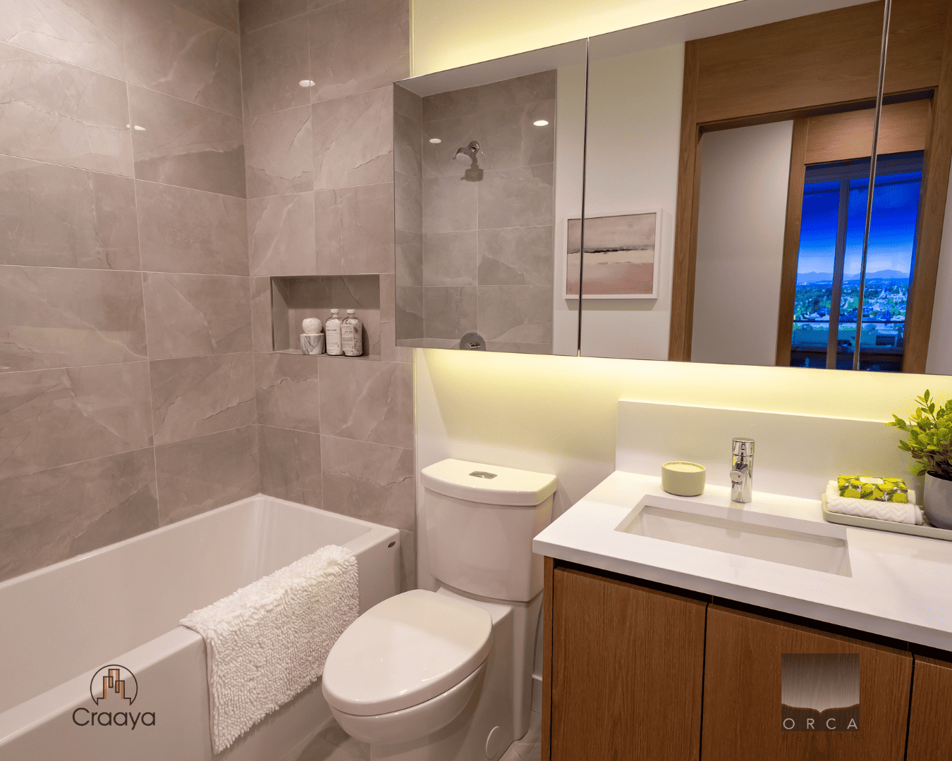 7 Modern bathroom with elegant gray tile walls, sleek vanity with a white countertop, built-in shower nook, and large mirror; ideal for showcasing upscale property amenities.