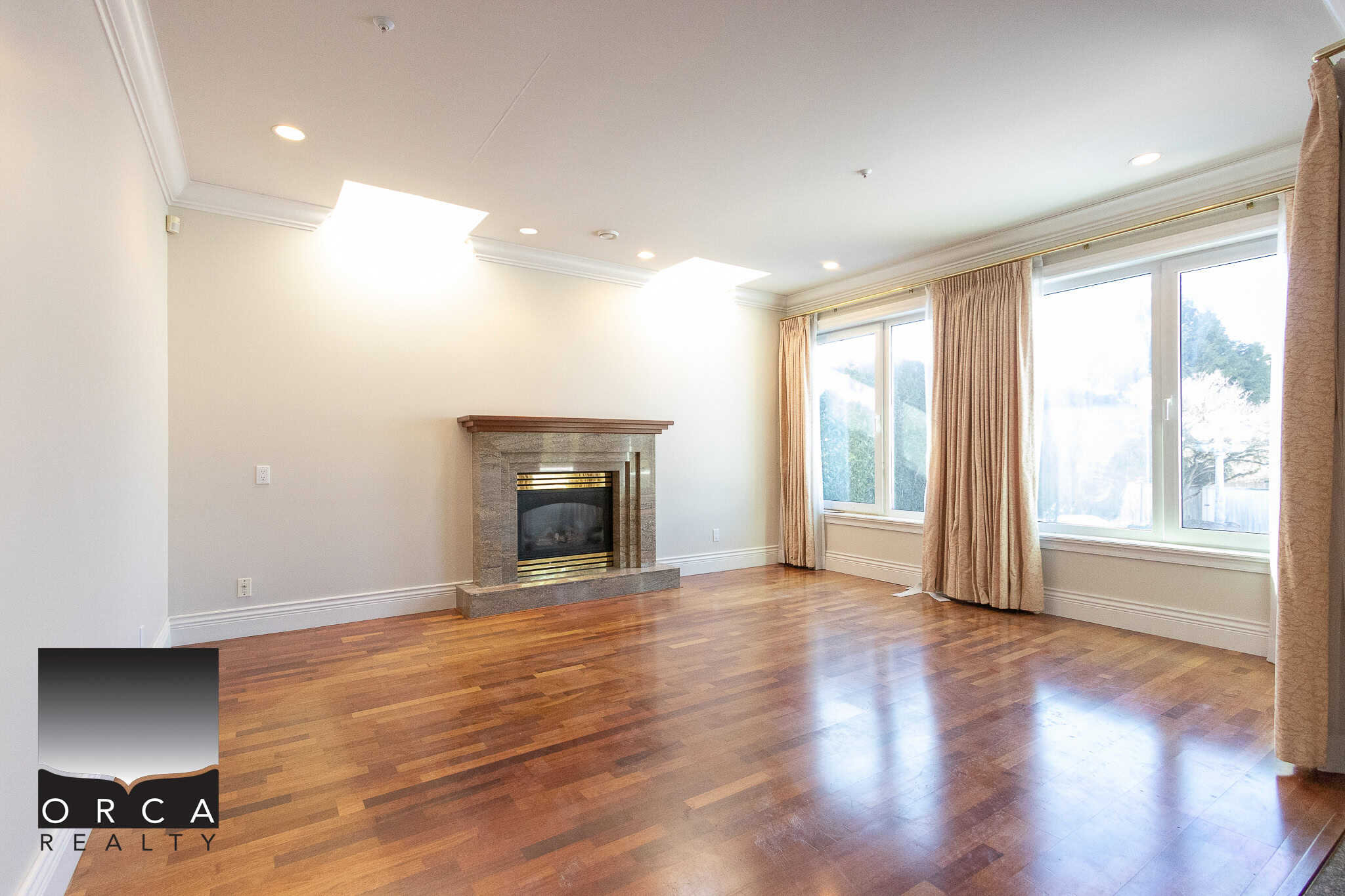 8 Spacious bright living room with hardwood flooring, large windows, a cozy fireplace, and neutral decor, ideal for Vancouver and BC real estate buyers.